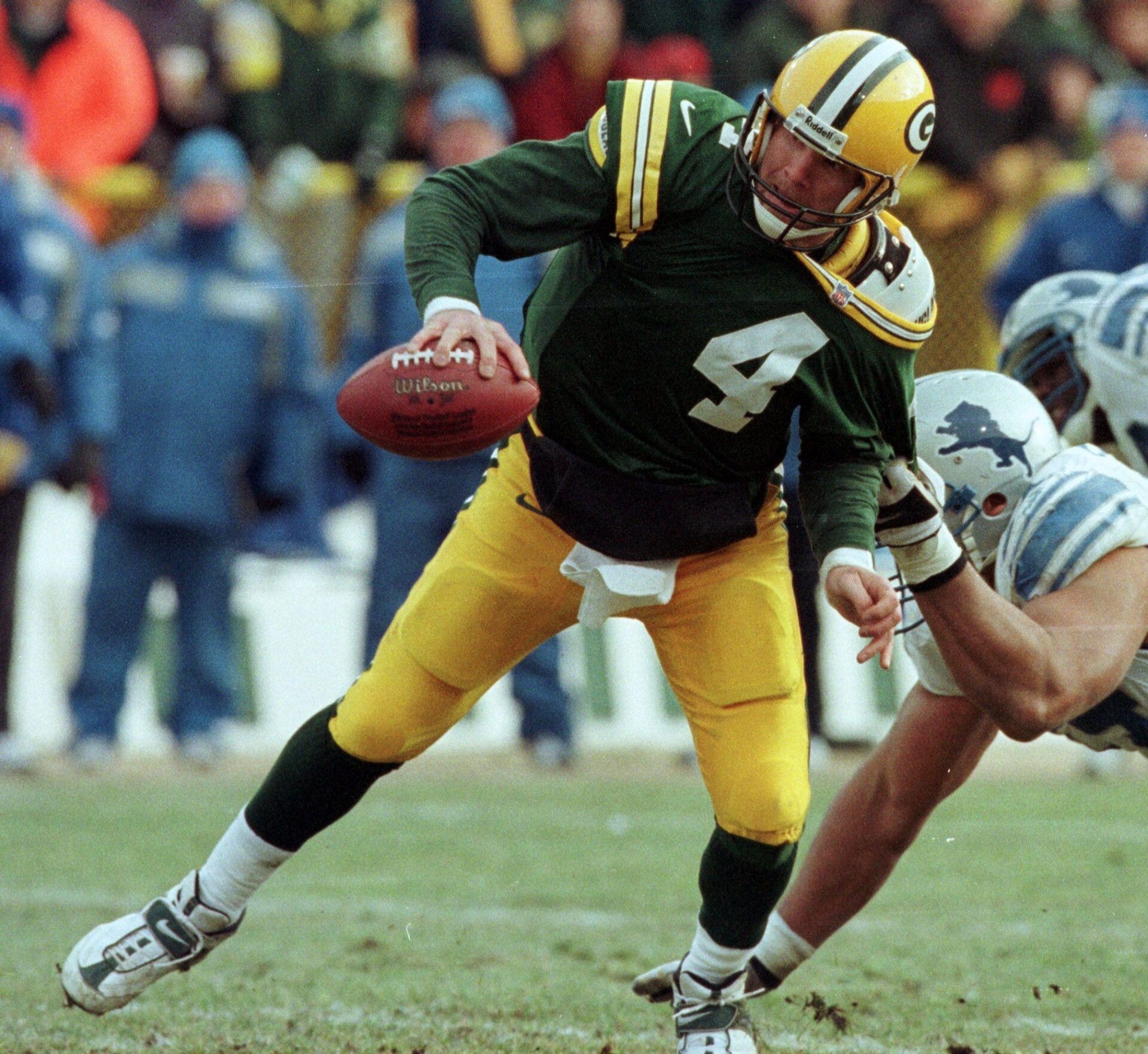 Green Bay Packers quarterback Brett Favre is able to get off a pass despite being dragged by Detroit Lions Luther Ellis during the second quarter of their game on Dec. 10, 2000 at Lambeau Field in Green Bay, Wis.