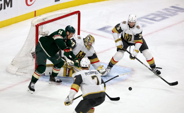 Apr 26, 2025; Saint Paul, Minnesota, USA; Minnesota Wild center Joel Eriksson Ek (14) looks for a loose puck in front of Vegas Golden Knights goaltender Adin Hill (33) during 1st OT in game four of the first round of the 2025 Stanley Cup Playoffs at Xcel Energy Center. Mandatory Credit: Bruce Fedyck-Imagn Images