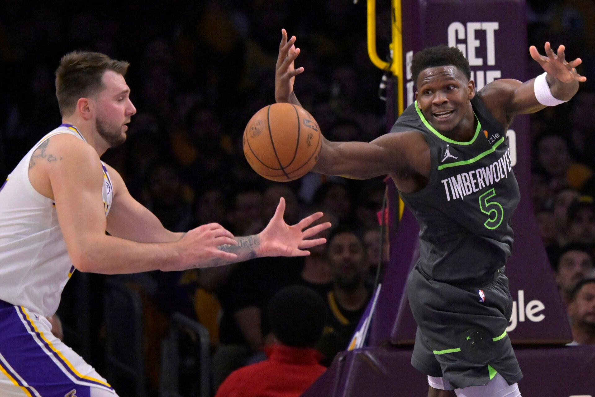 Apr 19, 2025; Los Angeles, California, USA; Los Angeles Lakers guard Luka Doncic (77) and Minnesota Timberwolves guard Anthony Edwards (5) reach for a loose ball in the first half at Crypto.com Arena. Mandatory Credit: Jayne Kamin-Oncea-Imagn Images