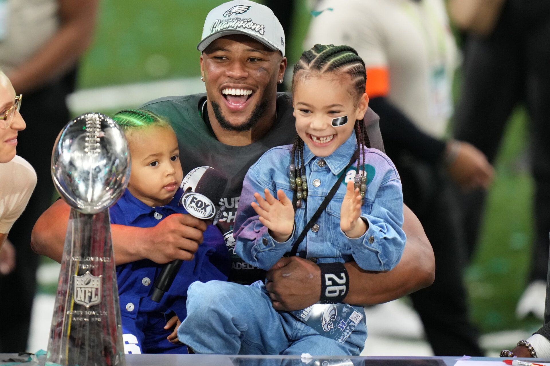 Feb 9, 2025; New Orleans, LA, USA; Philadelphia Eagles running back Saquon Barkley (26) talks to the media with his kids, Jada (right) and Saquon Jr. (left) after defeating the Kansas City Chiefs in Super Bowl LIX at Caesars Superdome. Mandatory Credit: Kirby Lee-Imagn Images