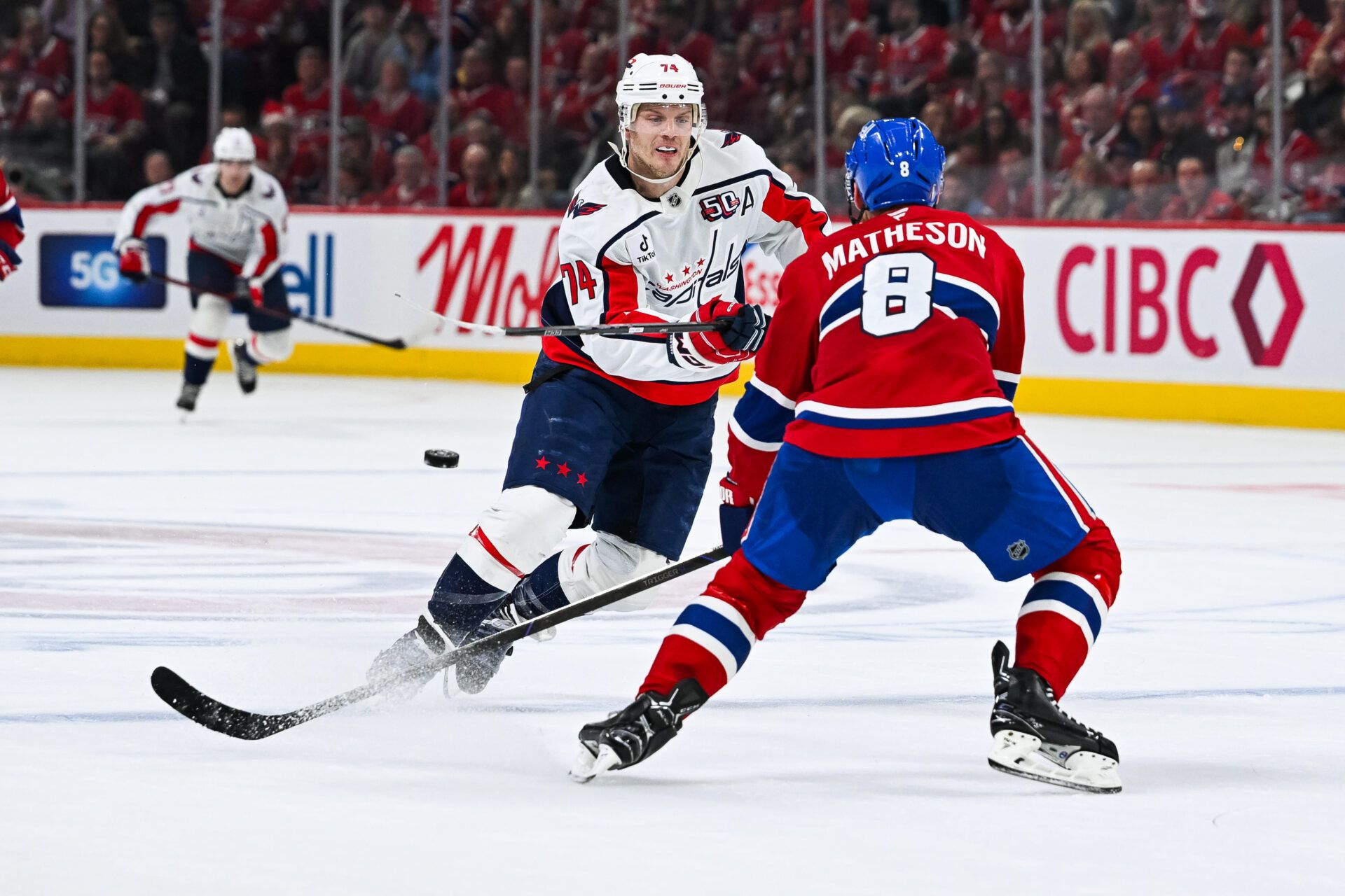 Apr 27, 2025; Montreal, Quebec, CAN; Washington Capitals defenseman John Carlson (74) shoots the puck beside Montreal Canadiens defenseman Mike Matheson (8) during the second period in game four of the first round of the 2025 Stanley Cup Playoffs at Bell Centre. Mandatory Credit: David Kirouac-Imagn Images