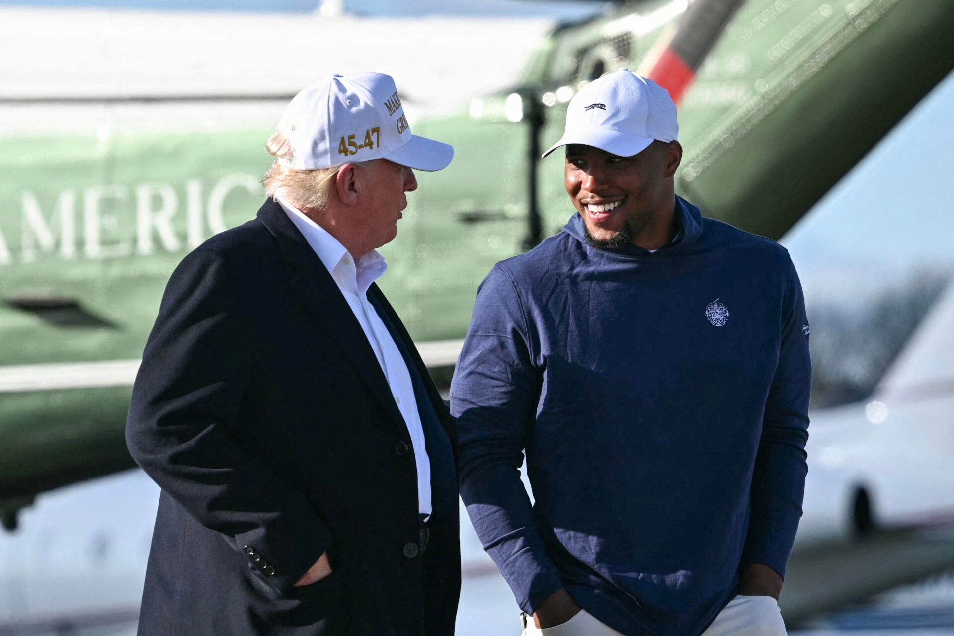 TOPSHOT - US President Donald Trump (L) walks with Philadelphia Eagles running back Saquon Barkley before boarding Air Force One Morristown Municipal Airport in Morristown, New Jersey, on April 27, 2025. Trump is returning to Washington, DC, from his residence in Bedminster, New Jersey, after traveling to Rome for the funeral of Pope Francis. (Photo by Mandel NGAN / AFP) (Photo by MANDEL NGAN/AFP via Getty Images)