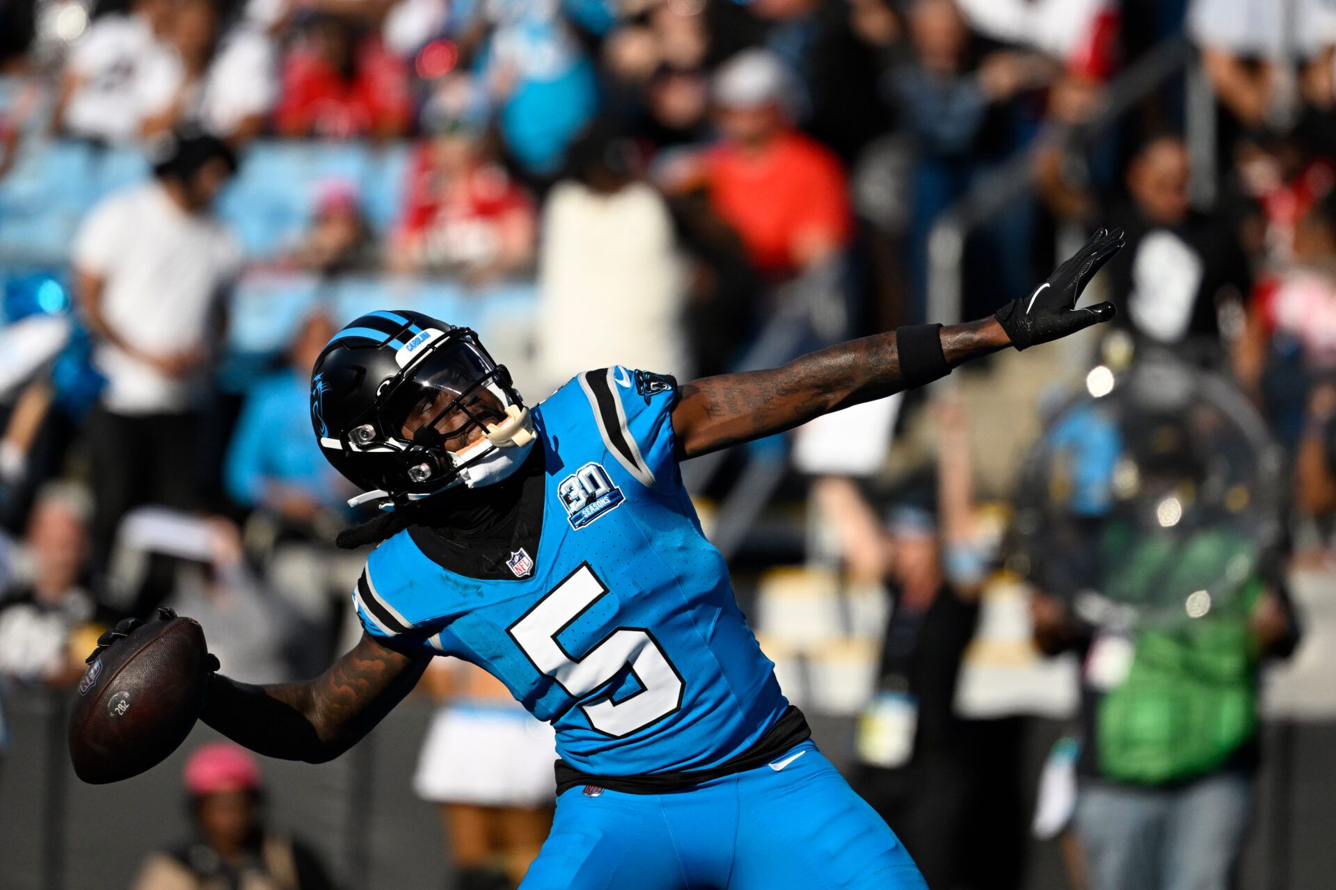 Oct 13, 2024; Charlotte, North Carolina, USA; Carolina Panthers wide receiver Diontae Johnson (5) celebrates by throwing the ball into the crowd after scoring a thouchdown in the first quarter at Bank of America Stadium. Mandatory Credit: Bob Donnan-Imagn Images