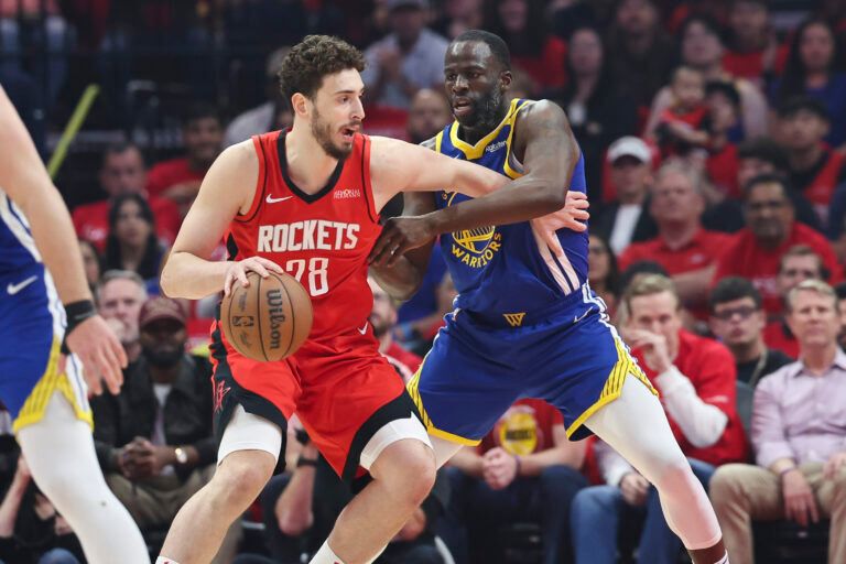 Apr 23, 2025; Houston, Texas, USA; Houston Rockets center Alperen Sengun (28) controls the ball as Golden State Warriors forward Draymond Green (23) defends during the first quarter during game two of the first round for the 2024 NBA Playoffs at Toyota Center. Mandatory Credit: Troy Taormina-Imagn Images