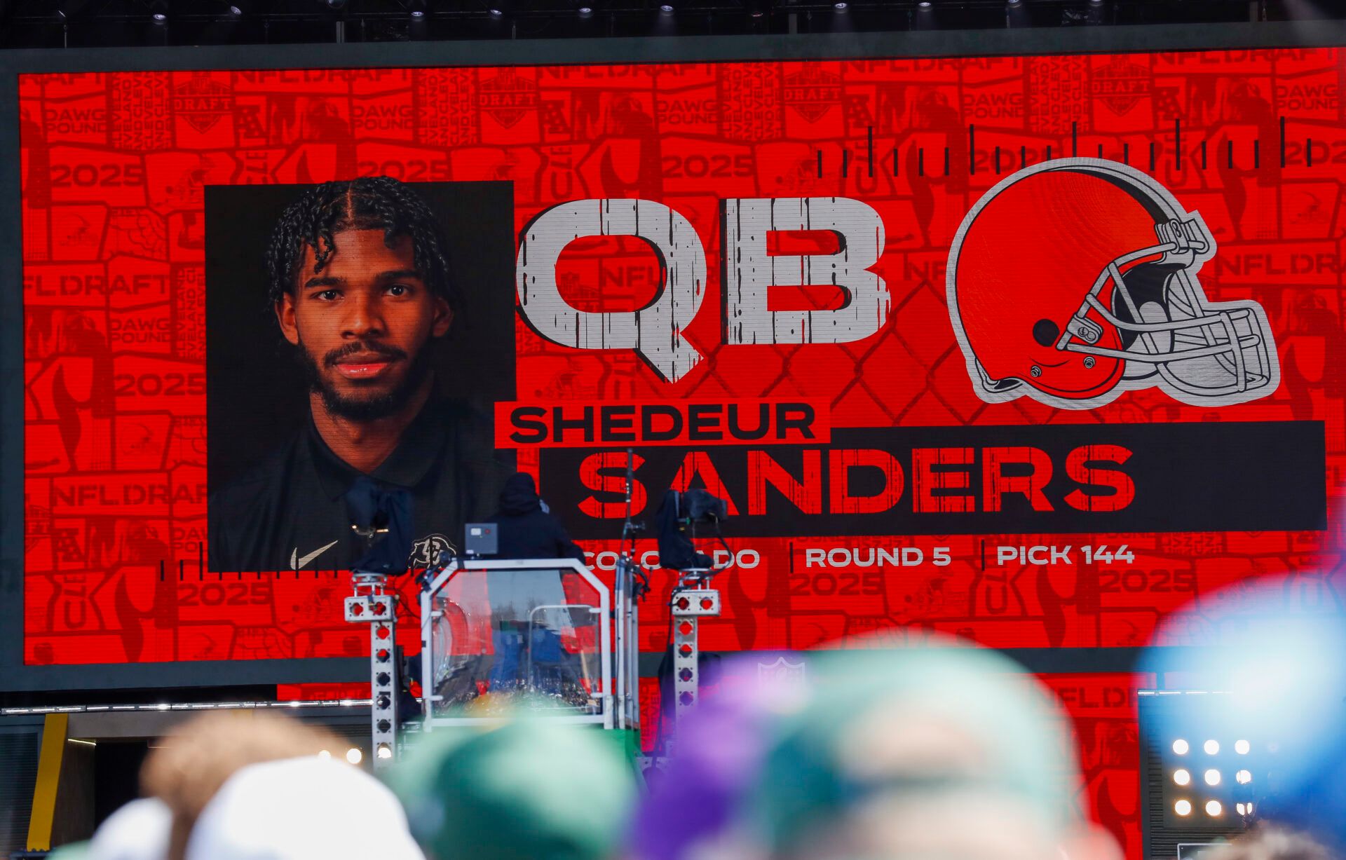 Apr 25, 2025; Green Bay, WI, USA; A graphic announcing Colorado quarterback Shedeur Sanders’ selection by the Cleveland Browns with the 144th overall pick is seen in the Draft Theater during the third day of the 2025 NFL Draft at Lambeau Field. Mandatory Credit: Tork Mason/USA Today Network via Imagn Images
