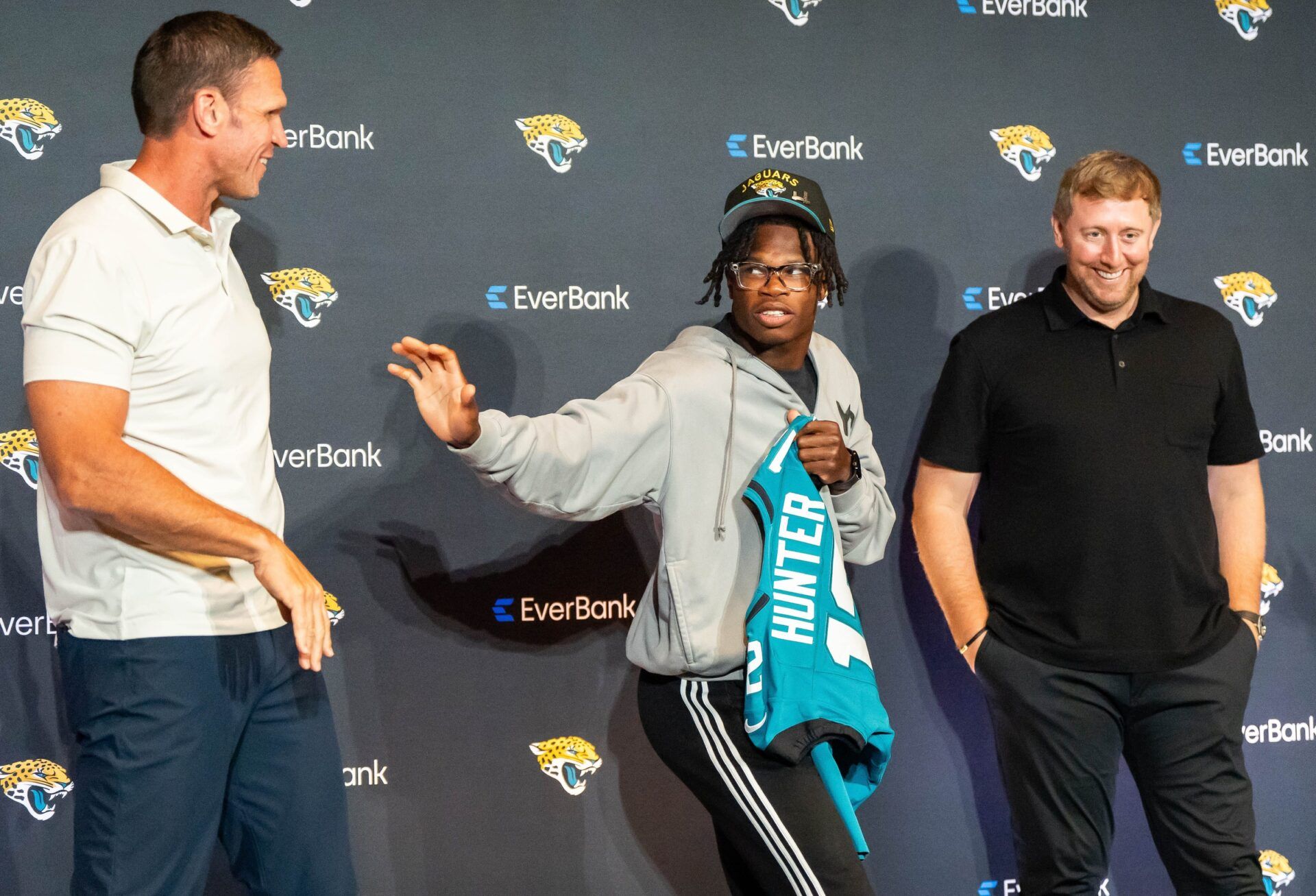 The Jacksonville Jaguars’ first-round pick, Colorado Buffaloes wide receiver and defensive back Travis Hunter, center, throws up the Heisman pose to Tony Boselli, Executive Vice President of Football Operations, left, as Head Coach Liam Coen, right, laughs after a press conference Friday, March 25, 2025 at Miller Electric Center in Jacksonville, Fla. The team traded up from fifth to second after making a deal with the Cleveland Browns on Thursday night. The rookie was introduced with general manager James Gladstone and head coach Liam Coen. [Doug Engle/Florida Times-Union]