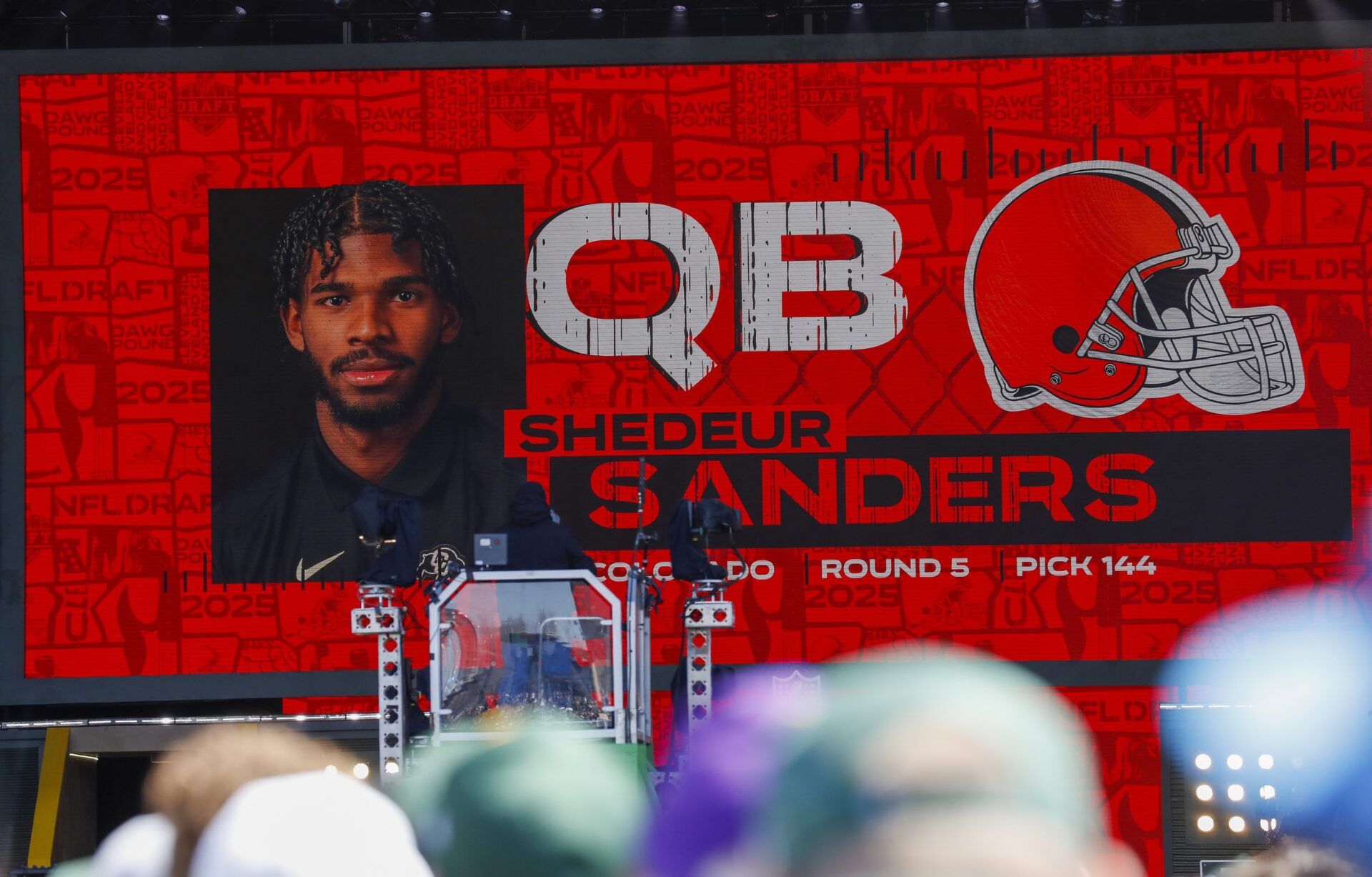 A graphic announcing Colorado quarterback Shedeur Sanders’ selection by the Cleveland Browns with the 144th overall pick is seen in the Draft Theater during the third day of the 2025 NFL Draft at Lambeau Field.