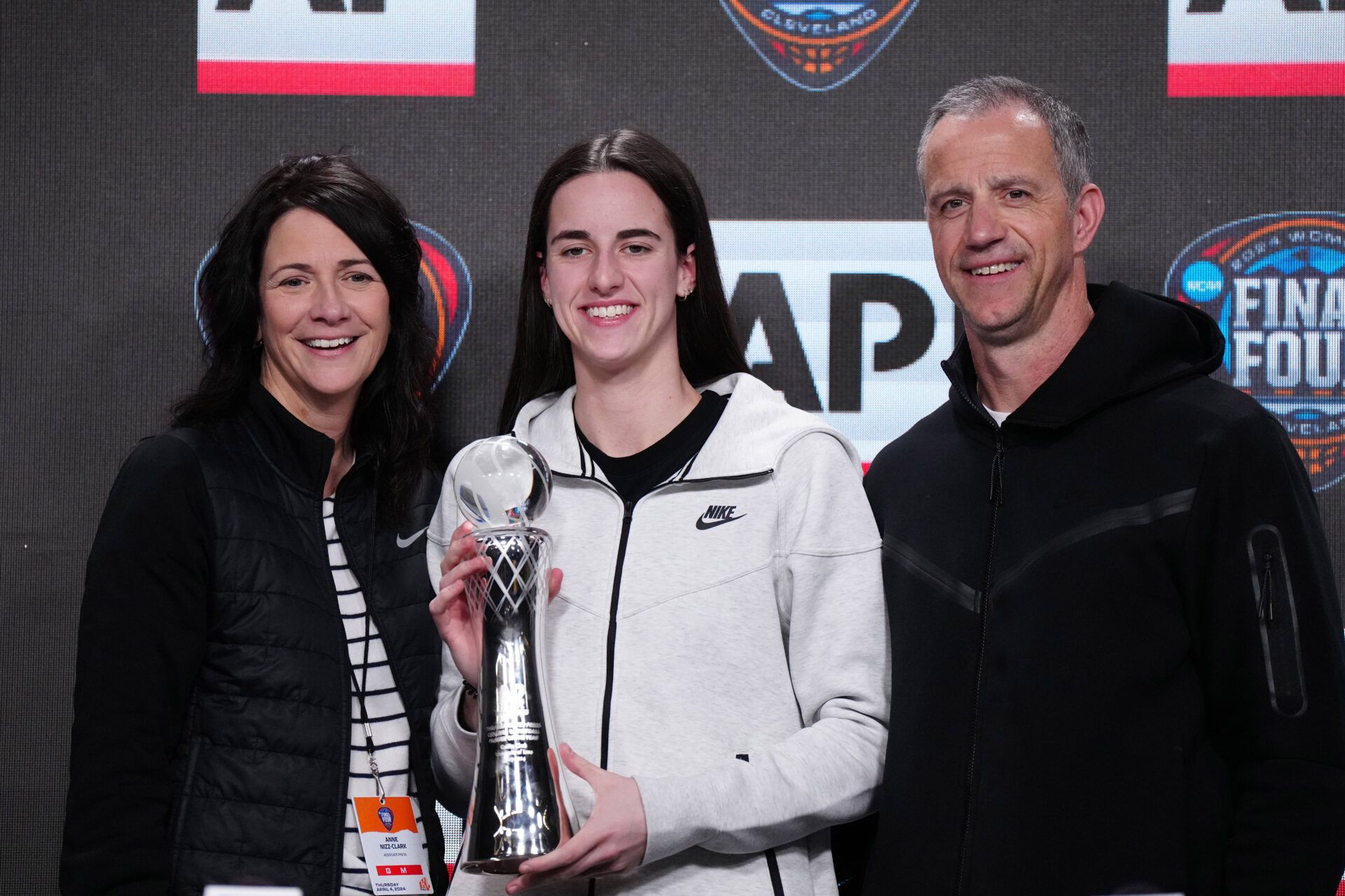 Apr 4, 2024; Cleveland, OH, USA; Iowa Hawkeyes guard Caitlin Clark (center) poses with mother Anne Clark (left) and father Brent Clark after being named the AP Player of the Year at a press conference at Rocket Mortgage FieldHouse. Mandatory Credit: Kirby Lee-USA TODAY Sports