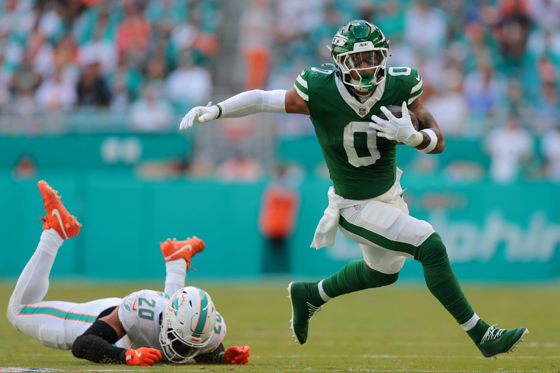 New York Jets running back Braelon Allen (0) runs past Miami Dolphins linebacker Jordyn Brooks (20) during the first quarter at Hard Rock Stadium.