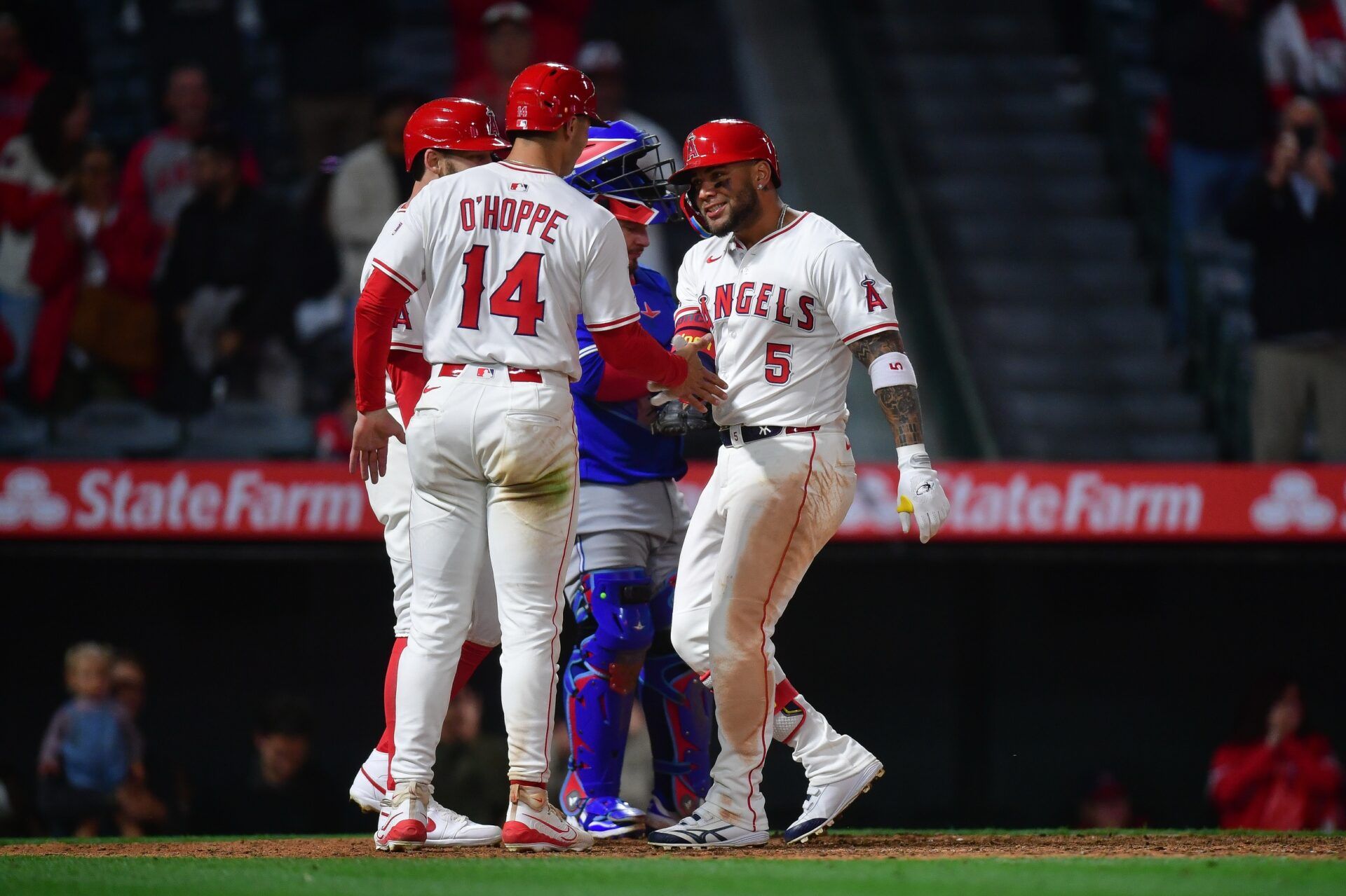 Los Angeles Angels third baseman Yoan Moncada (5) is greeted by catcher Logan O'Hoppe (14) and left fielder Taylor Ward (3) after hitting a three run home run against the Toronto Blue Jays during the eighth inning at Angel Stadium.