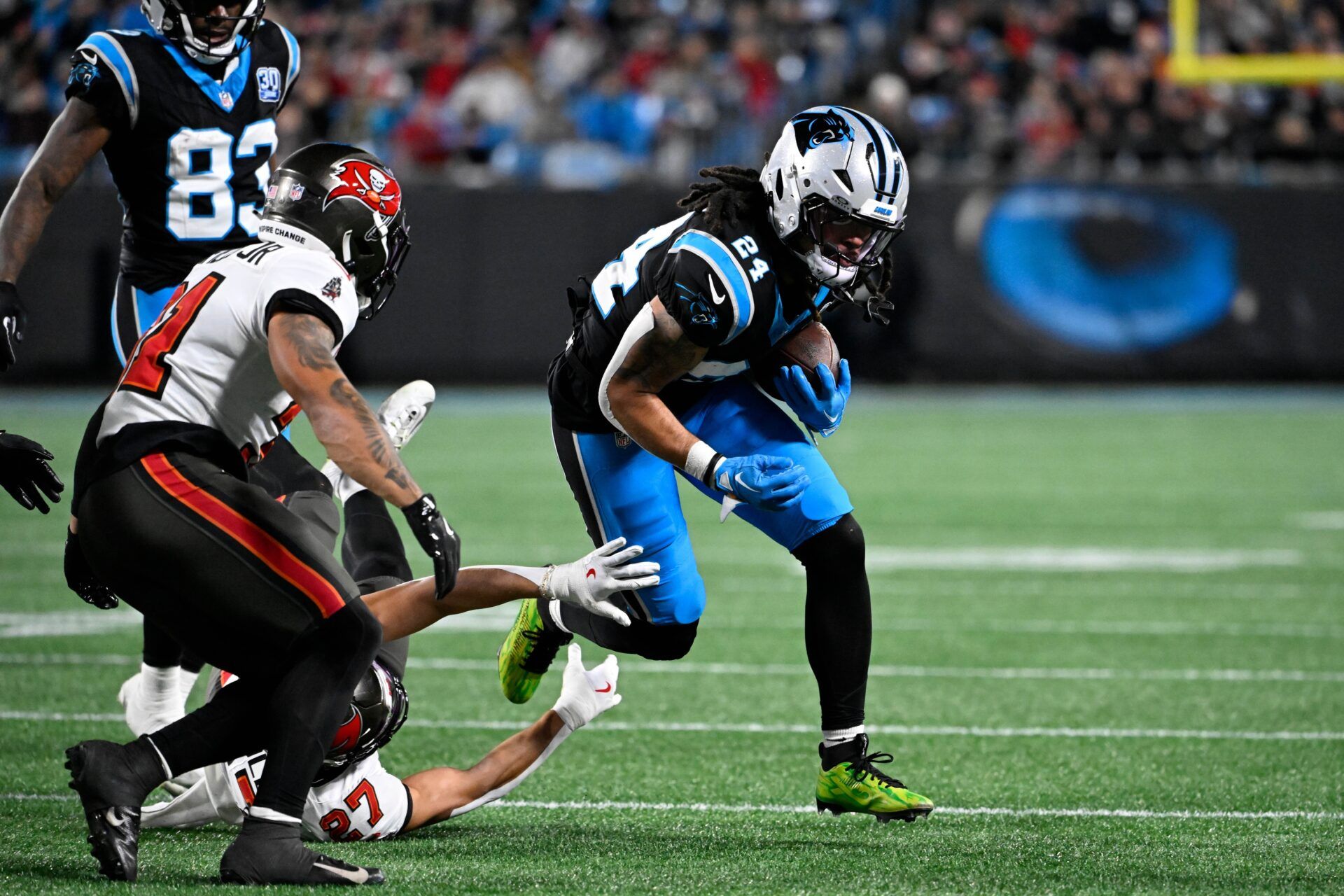 Carolina Panthers running back Jonathon Brooks (24) runs as Tampa Bay Buccaneers cornerback Zyon McCollum (27) defends in the third quarter at Bank of America Stadium.