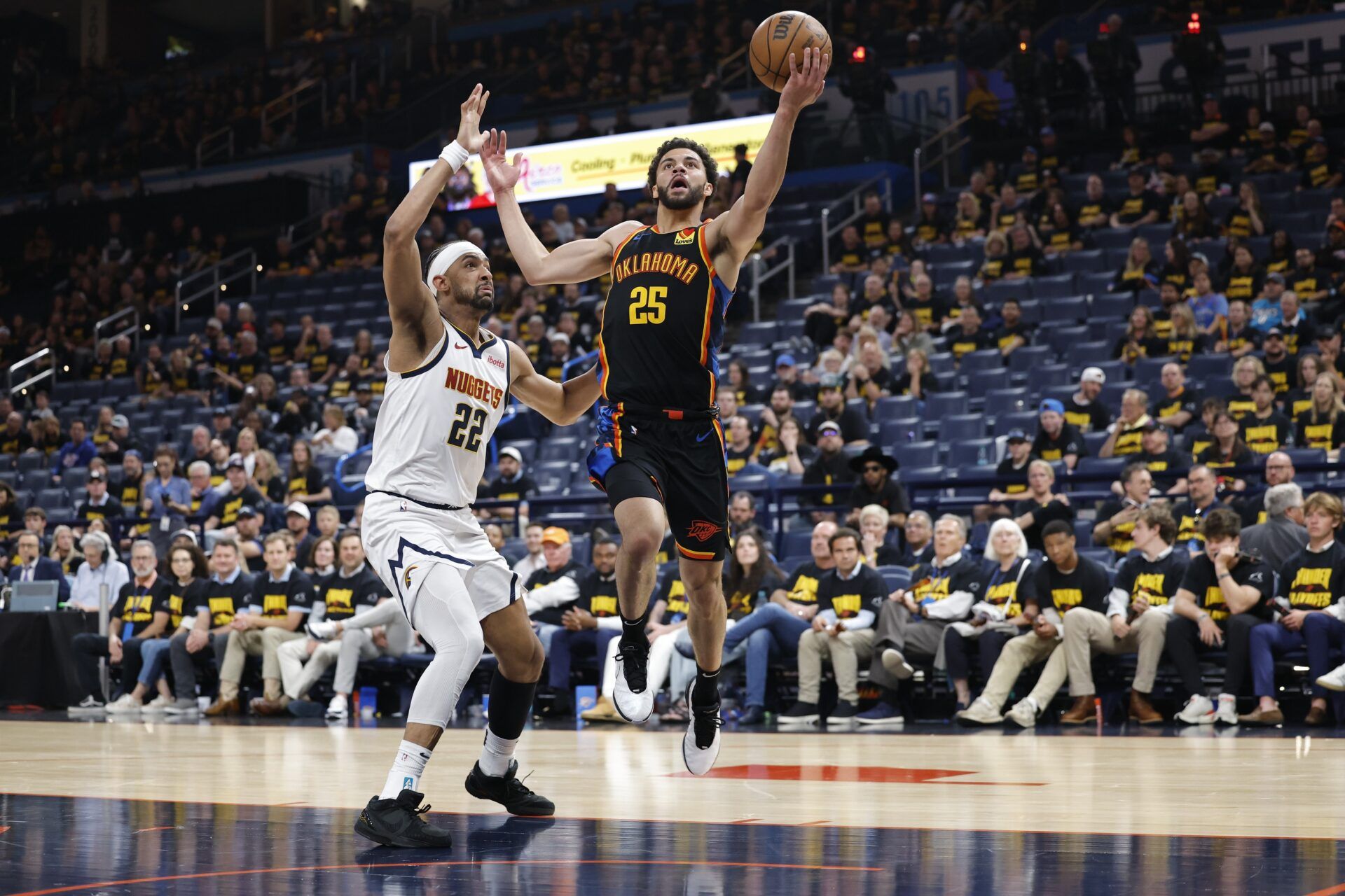 Oklahoma City Thunder guard Ajay Mitchell (25) drives to the basket beside Denver Nuggets forward Zeke Nnaji (22) in the second half during game two of the second round for the 2025 NBA Playoffs at Paycom Center.