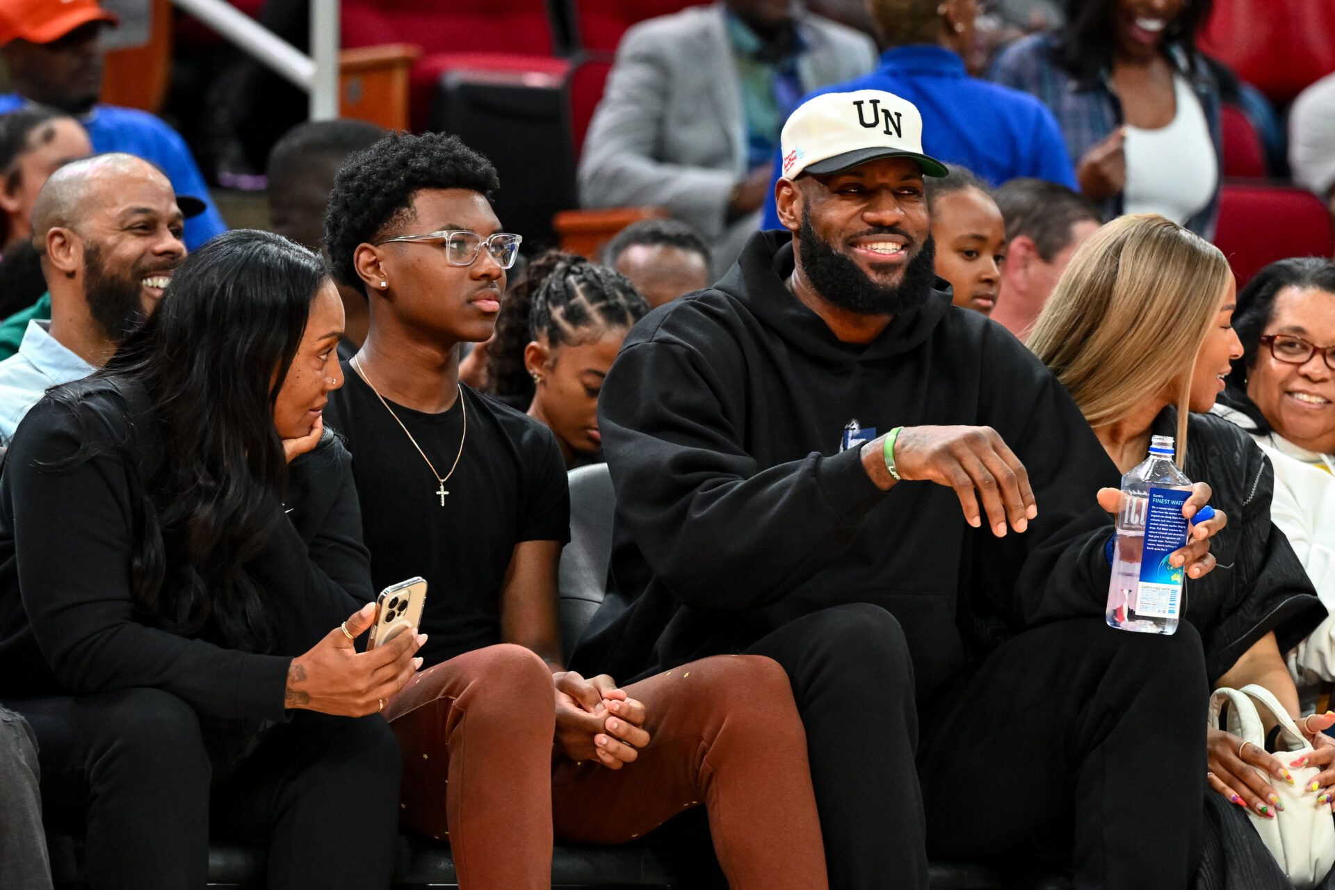Los Angeles Lakers forward LeBron James sits with his wife Savannah James (right), son Bryce Maximus James (left) and his mother Gloria Marie James (left) court side of the between the McDonald's All American East and the McDonald's All American West at Toyota Center.