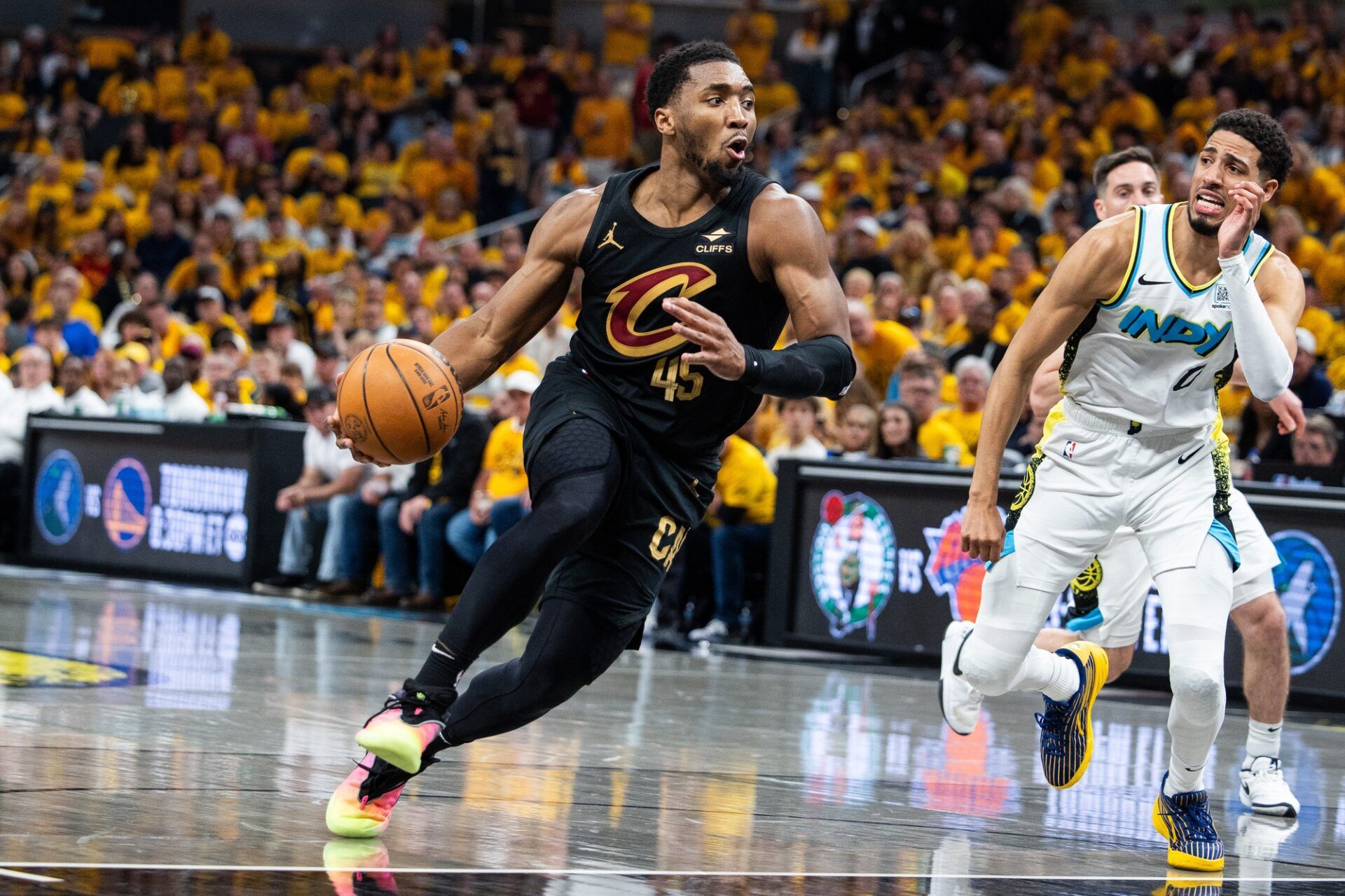 Cleveland Cavaliers guard Donovan Mitchell (45) dribbles  the ball while Indiana Pacers guard Tyrese Haliburton (0) defends during game three of the second round for the 2025 NBA Playoffs at Gainbridge Fieldhouse.
