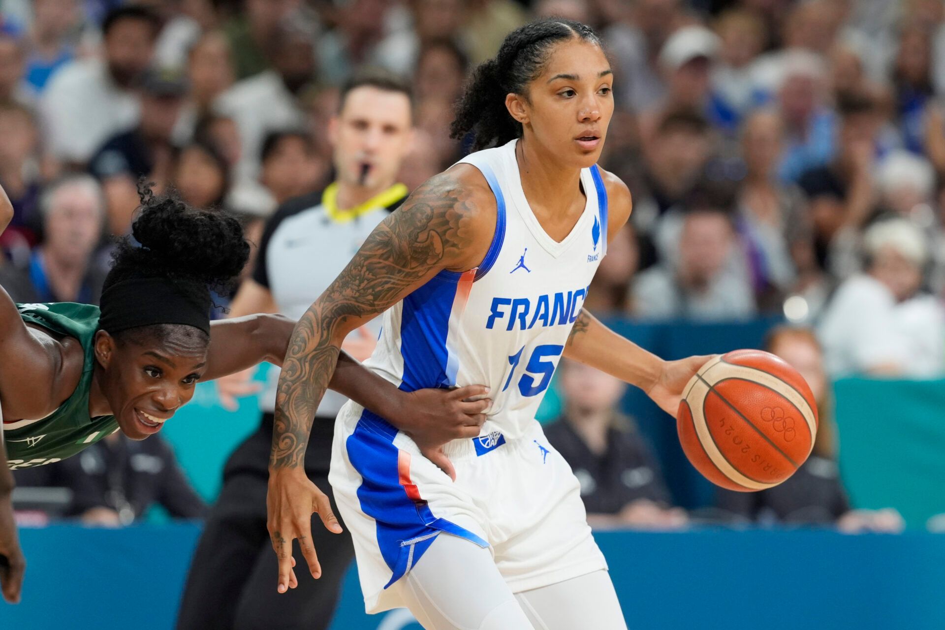 France forward Gabby Williams (15) controls the ball against Nigeria point guard Promise Amukamara (10) in the second half in a women’s group stage game during the Paris 2024 Olympic Summer Games at Stade Pierre-Mauroy.