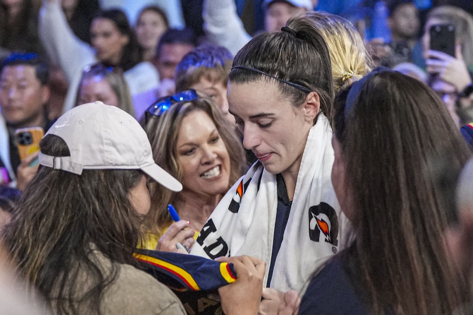 Indiana Fever guard Caitlin Clark (22) signs autographs on her way off the court after the Fever defeated the Atlanta Dream at Gateway Center Arena @ College Park.