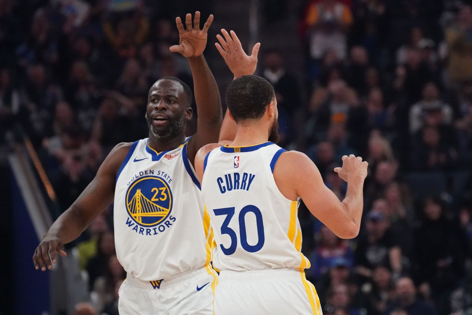Golden State Warriors forward Draymond Green (23) and guard Stephen Curry (30) high-five during the first quarter against the Detroit Pistons at Chase Center.