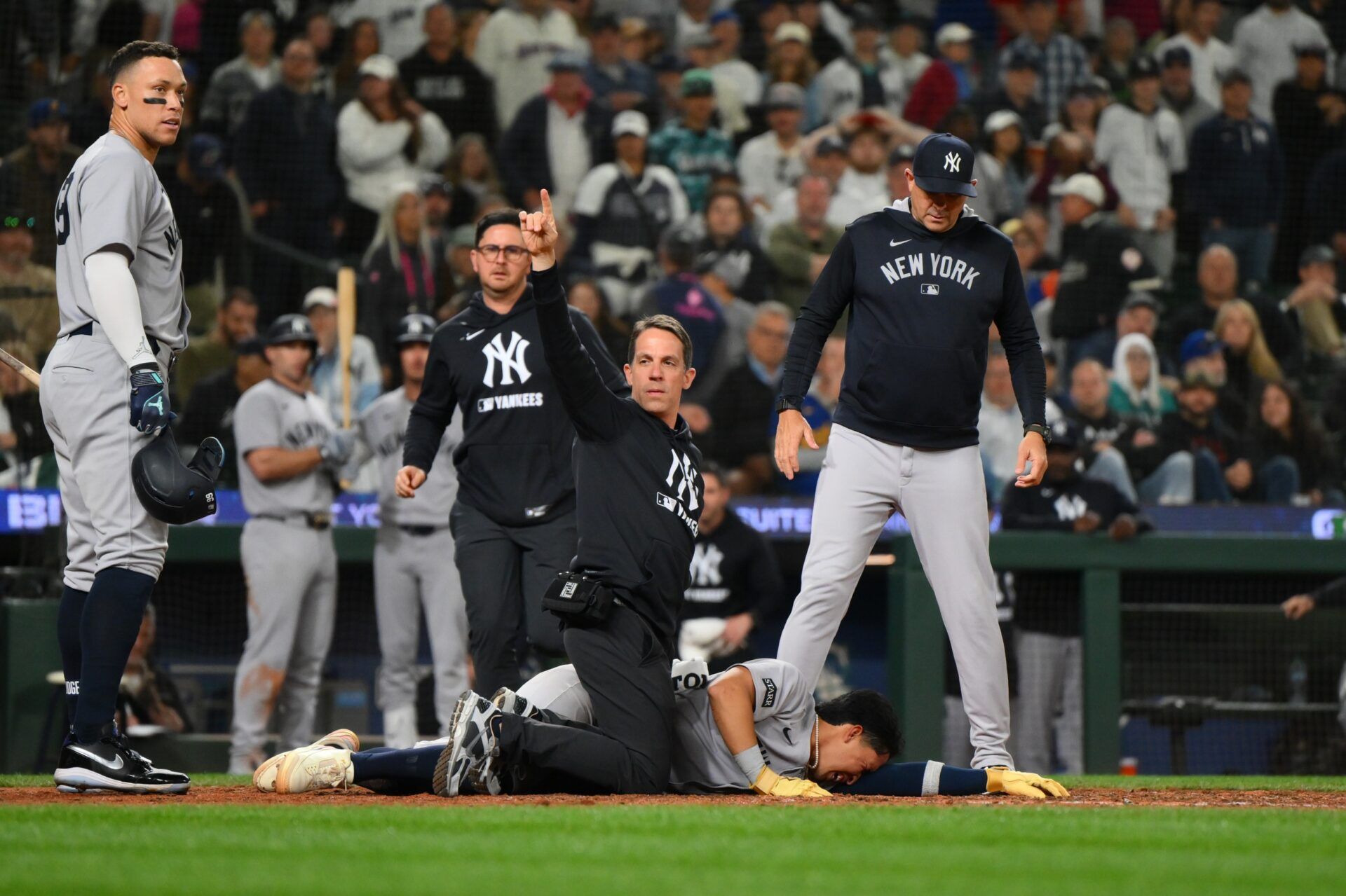 Trainers tend to New York Yankees third baseman Oswaldo Cabrera (95) after being injured while scoring a run against the Seattle Mariners during the ninth inning at T-Mobile Park.