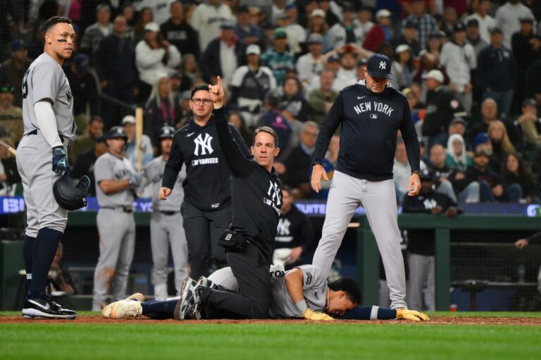 Trainers tend to New York Yankees third baseman Oswaldo Cabrera (95) after being injured while scoring a run against the Seattle Mariners during the ninth inning at T-Mobile Park.