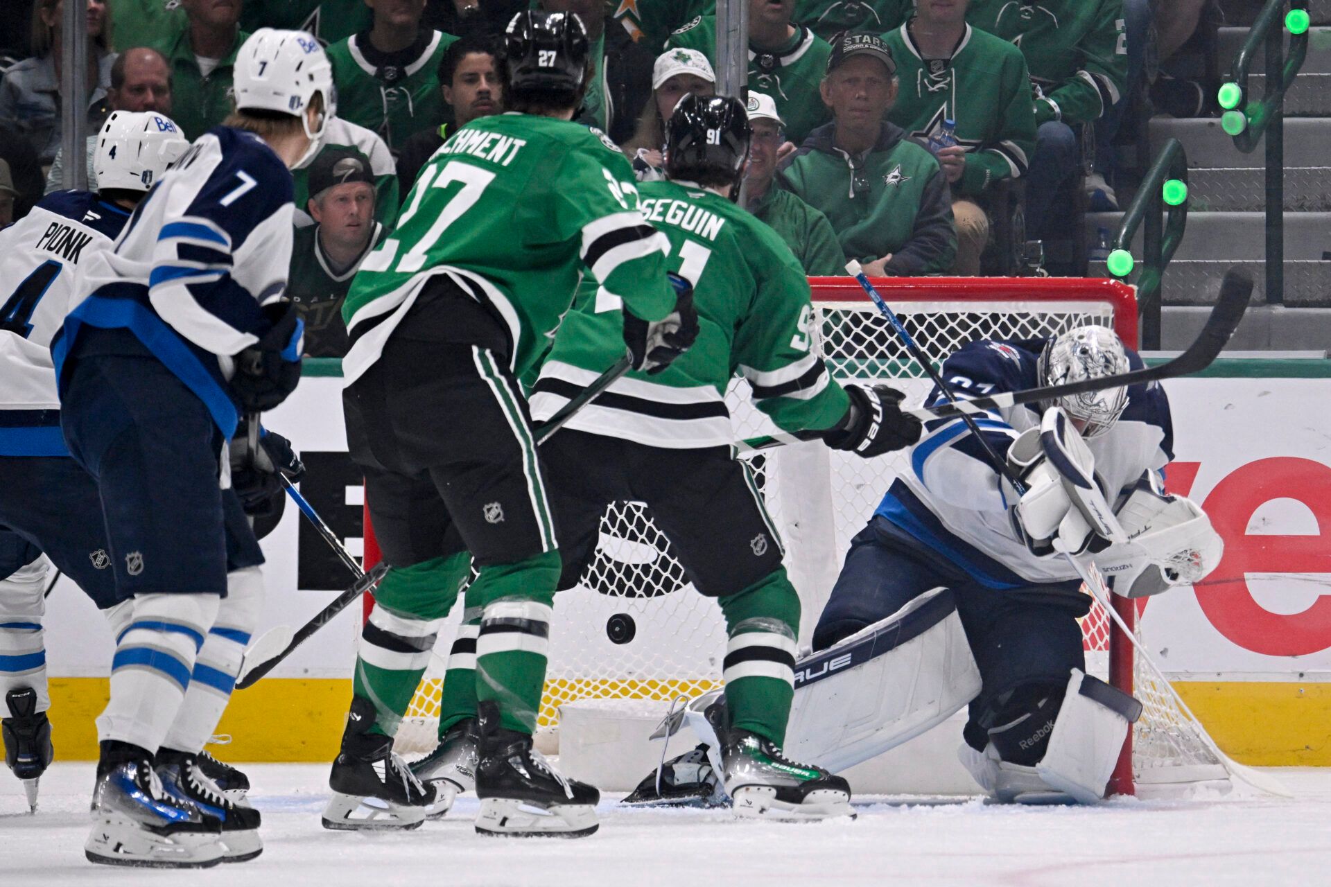 Winnipeg Jets goaltender Connor Hellebuyck (37) allows a goal to Dallas Stars center Mikael Granlund (not pictured) as left wing Mason Marchment (27) and center Tyler Seguin (91) look on during the third period in game four of the second round of the 2025 Stanley Cup Playoffs at American Airlines Center.