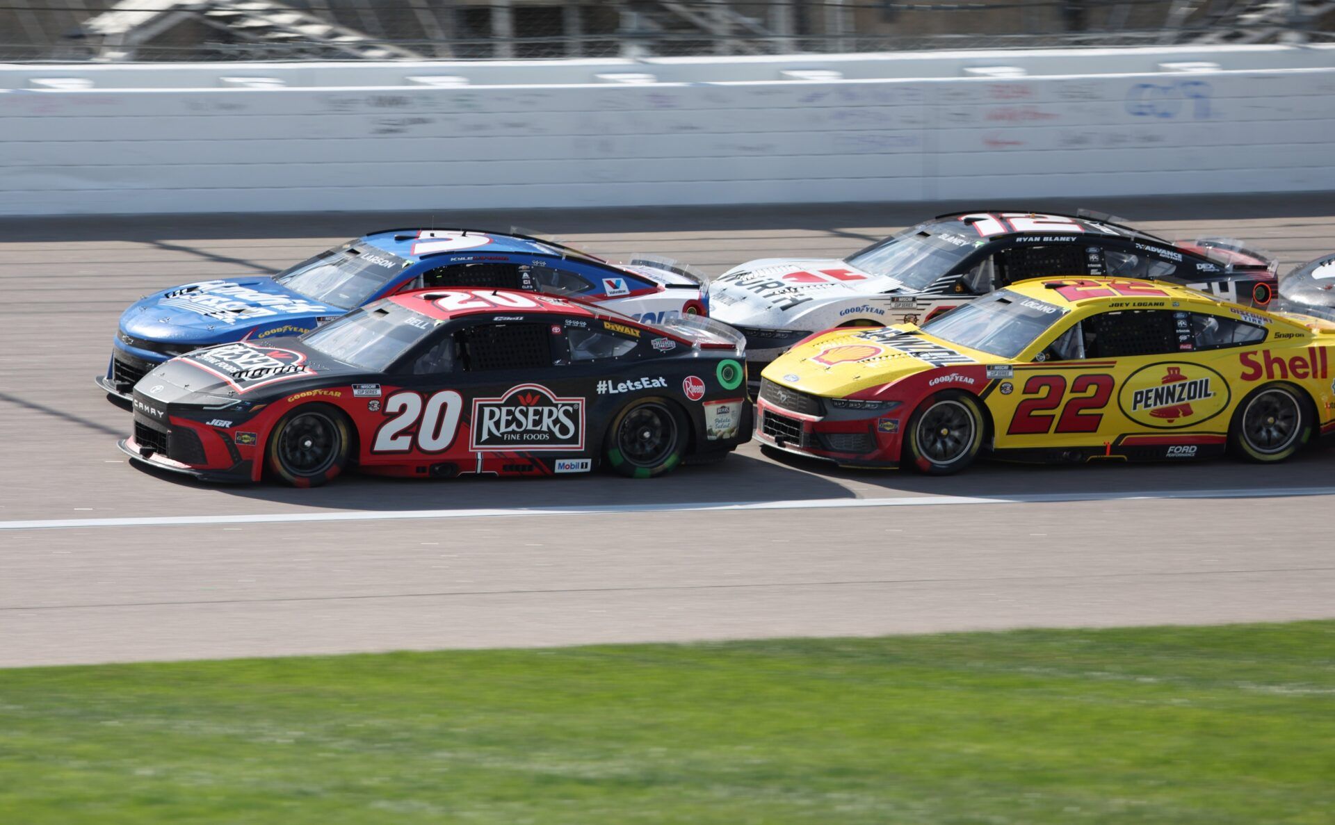 NASCAR Cup Series drivers Christopher Bell (20) and Kyle Larson (5) lead the pack during a restart late in the AdventHealth 400 at Kansas Speedway.