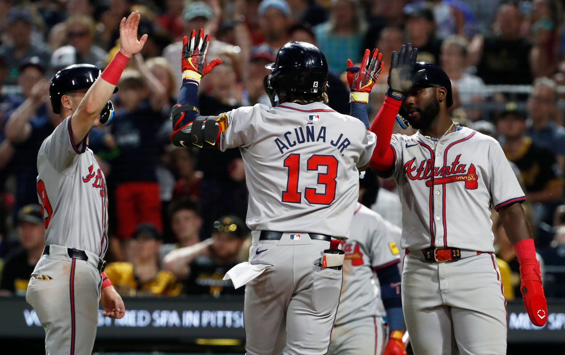 Atlanta Braves third baseman Zack Short (left) and Atlanta center fielder Michael Harris II (right) congratulate right fielder  Ronald Acuna Jr. (13) crossing home plate on a three-run home run against the Pittsburgh Pirates during the eighth inning at PNC Park.