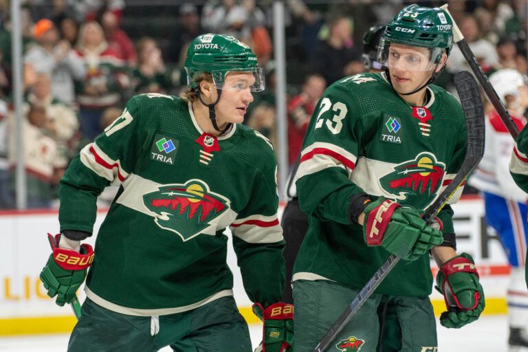 Minnesota Wild left wing Kirill Kaprizov (97) celebrates a goal and congratulates Minnesota Wild center Marco Rossi (23) on his first NHL assist in the second period at Xcel Energy Center.