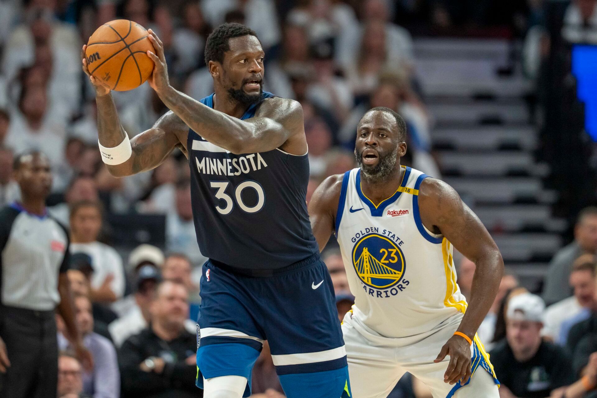 Minnesota Timberwolves forward Julius Randle (30) holds the ball as Golden State Warriors forward Draymond Green (23) plays defense in the second half during game five of the second round for the 2025 NBA Playoffs at Target Center.