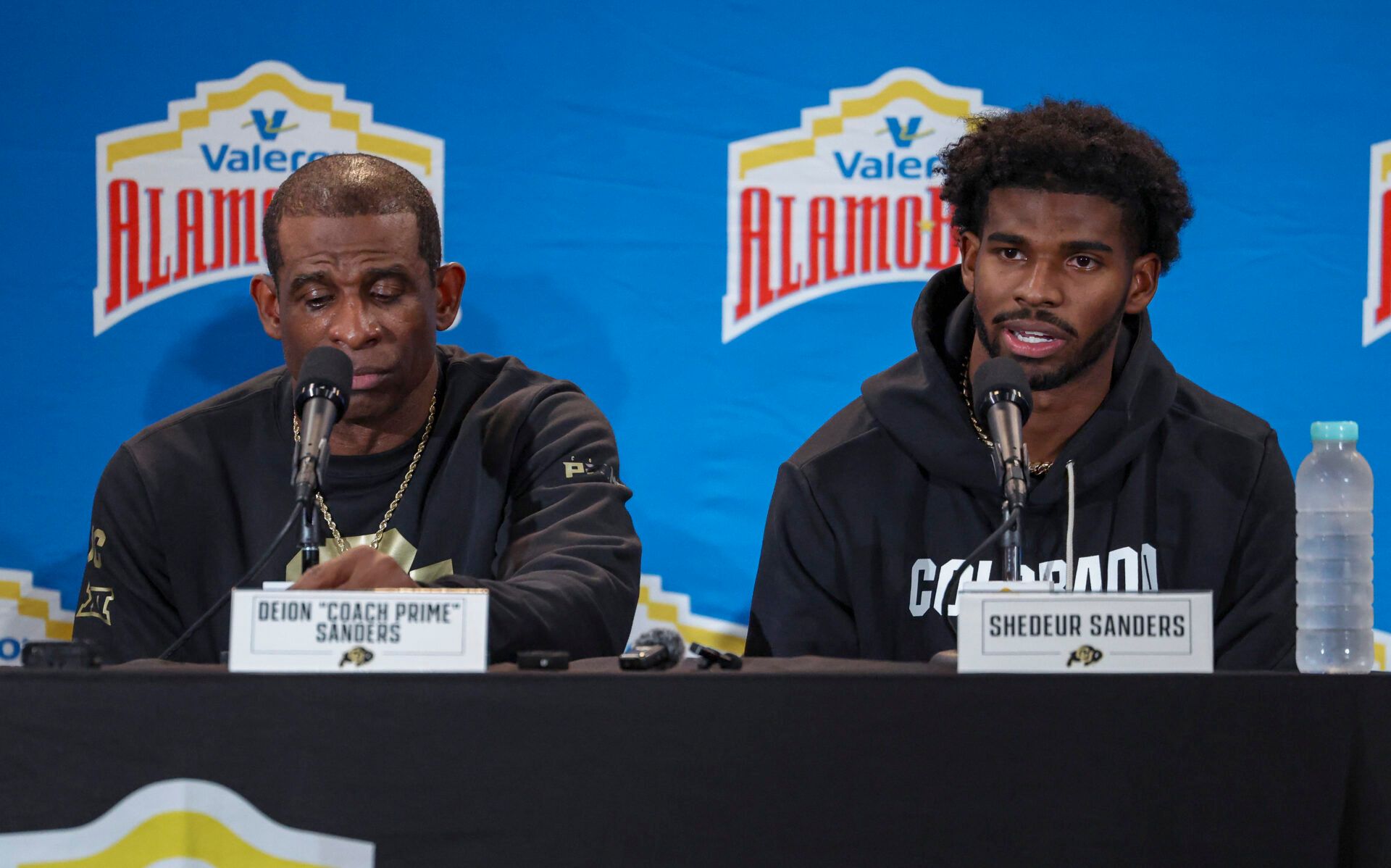 Colorado Buffaloes head coach Deion Sanders and quarterback Shedeur Sanders (2) talk with the media after the game against the Brigham Young Cougars at Alamodome.