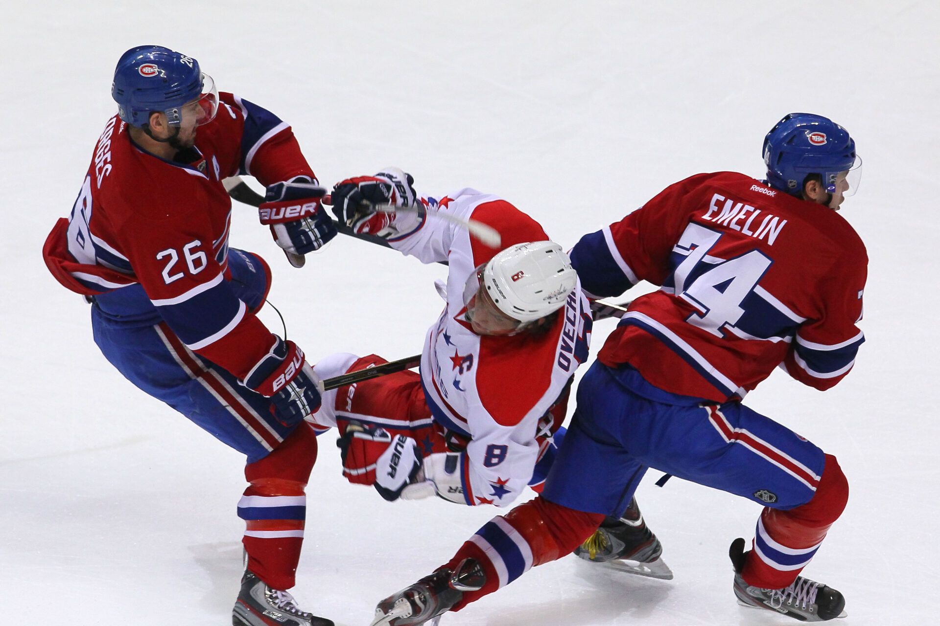 Washington Capitals captain Alex Oveckkin (8) is checked by Montreal Canadiens defenseman Josh Gorges (26) as defenseman Alexei Emelin (74) passes on during the first period at the Bell Center in Montreal, Quebec, Canada.