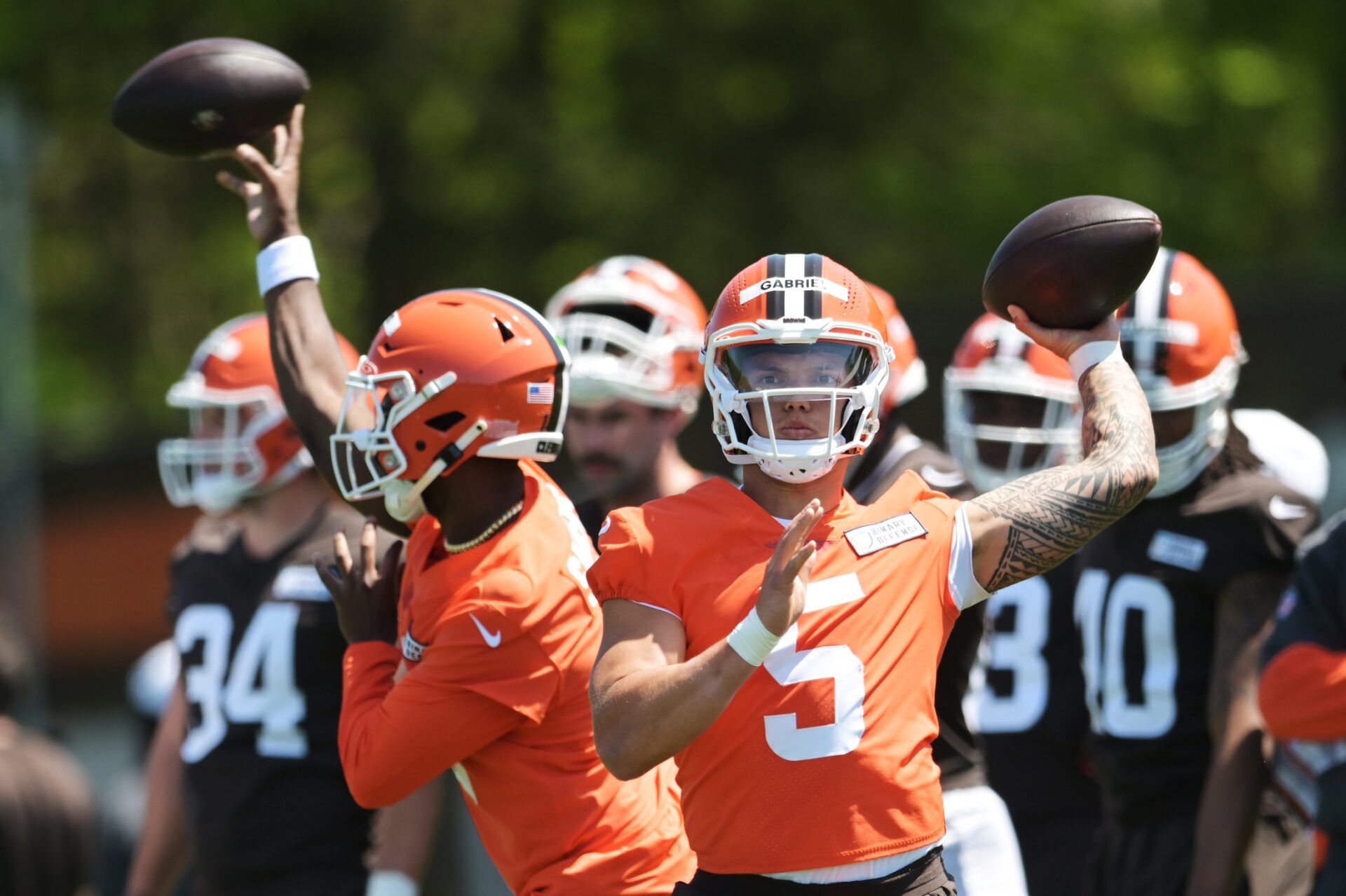 Cleveland Browns quarterback Dillon Gabriel (5) and quarterback Shedeur Sanders (12) throw passes during rookie minicamp at CrossCountry Mortgage Campus.