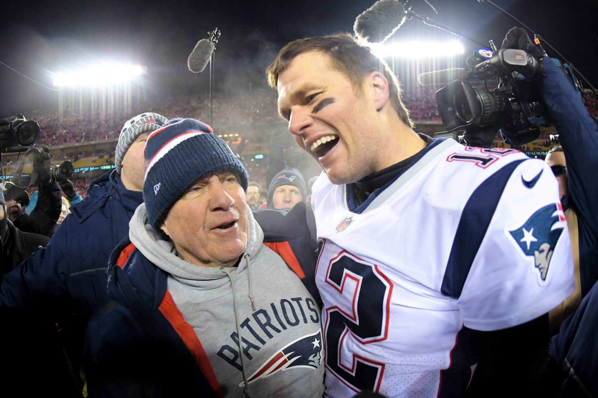 New England Patriots head coach Bill Belichick and quarterback Tom Brady (12) celebrate the win over the Kansas City Chiefs during overtime in the AFC Championship game at Arrowhead Stadium.
