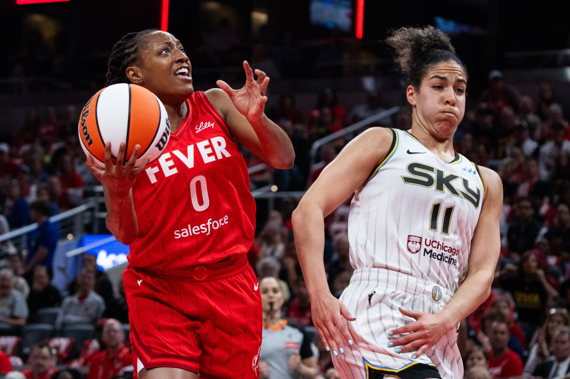 Indiana Fever guard Kelsey Mitchell (0) shoots the ball while Chicago Sky guard Kia Nurse (11) defends in the first half at Gainbridge Fieldhouse.