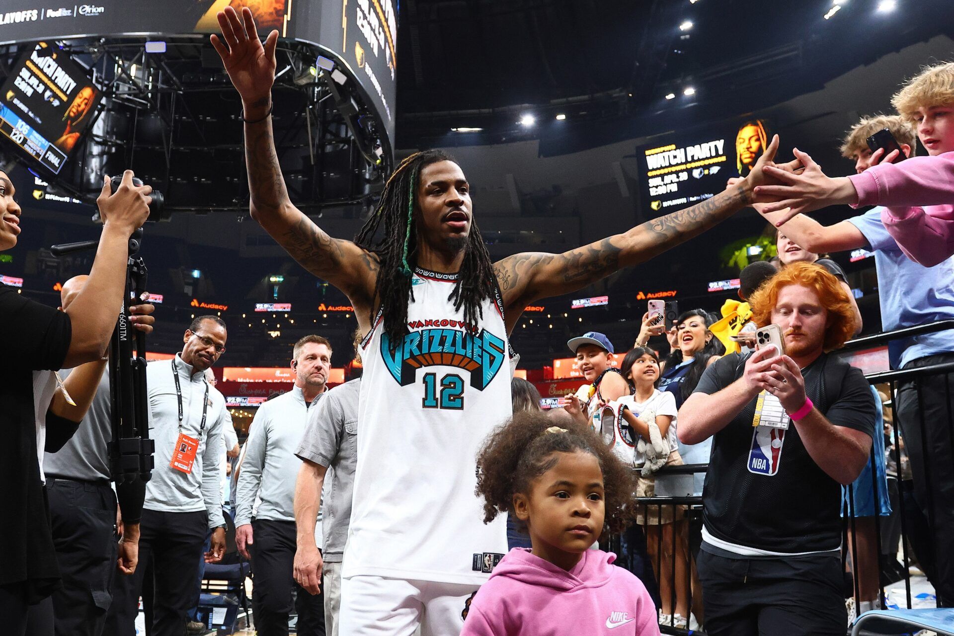 Memphis Grizzlies guard Ja Morant (12) walks off the court with his daughter, Kaari Morant, after defeating the Dallas Mavericks at FedExForum.