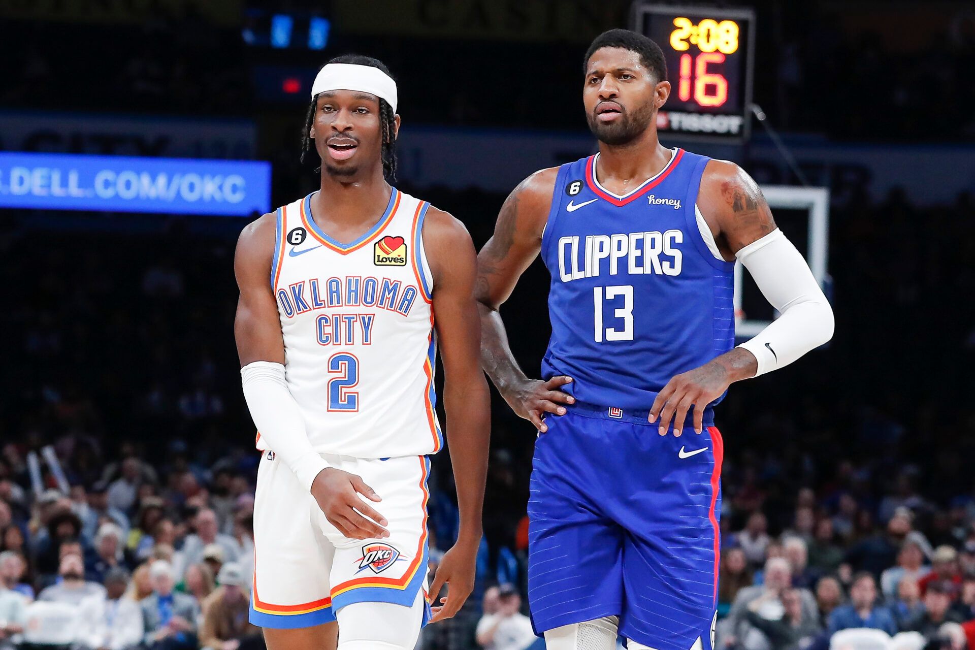 Oklahoma City Thunder guard Shai Gilgeous-Alexander (2) and LA Clippers guard Paul George (13) walks down the court during a time out during the first half at Paycom Center.