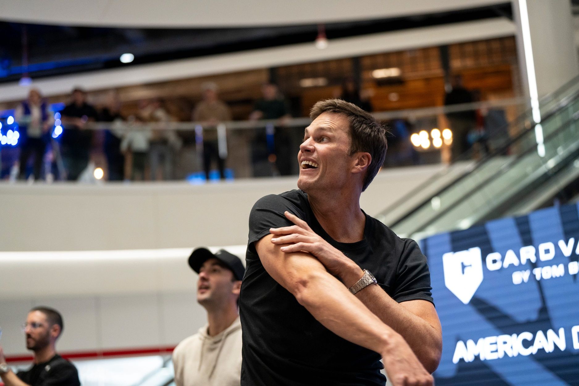 Tom Brady throws a football to a fan at American Dream during the grand opening of Card Vault by Tom Brady, a sports card and memorabilia retailer, East Rutherford, Friday, Apr. 11, 2025.