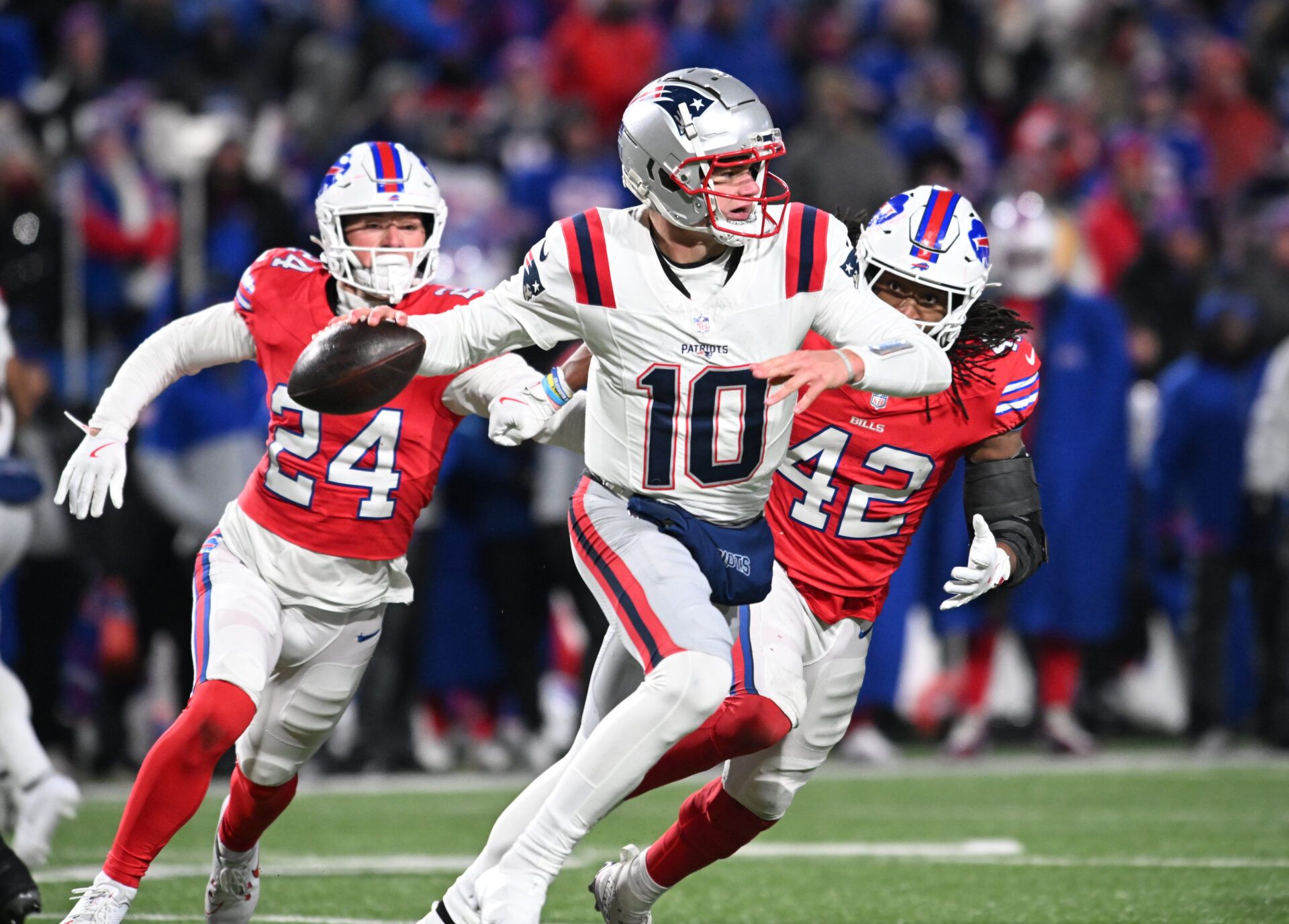 New England Patriots quarterback Drake Maye (10) throws a pass under pressure from Buffalo Bills safety Cole Bishop (24) and linebacker Dorian Williams (42) in the fourth quarter at Highmark Stadium.