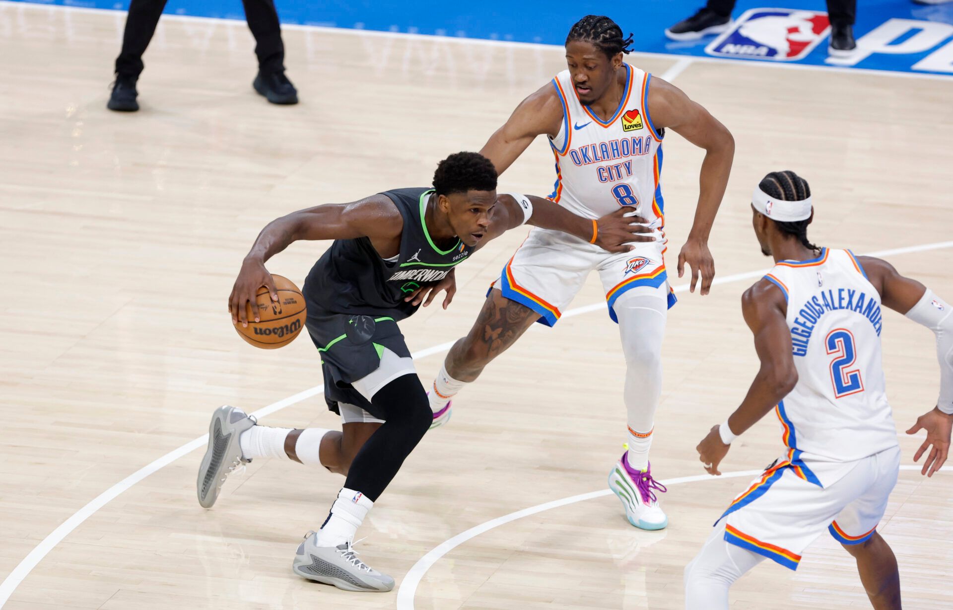 Minnesota Timberwolves guard Anthony Edwards (5) drives against Oklahoma City Thunder forward Jalen Williams (8) and guard Shai Gilgeous-Alexander (2) in the third quarter during game one of the western conference finals for the 2025 NBA Playoffs at Paycom Center.