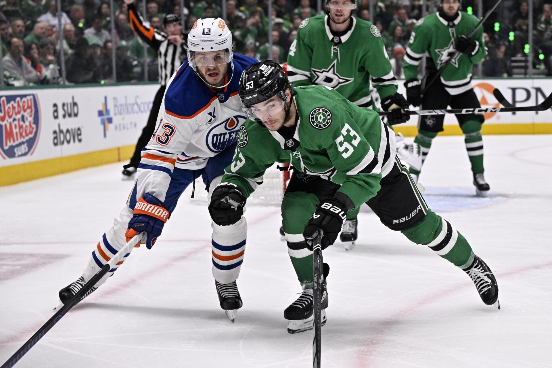 Dallas Stars center Wyatt Johnston (53) and Edmonton Oilers center Mattias Janmark (13) skate for a loose puck in the third period during game one of the Western Conference Final of the 2025 Stanley Cup Playoffs at American Airlines Center.