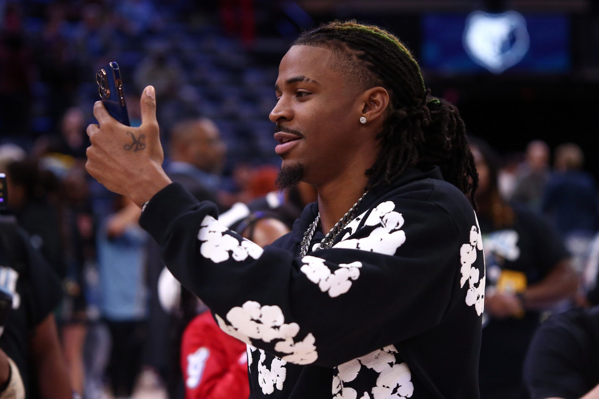 Memphis Grizzlies guard Ja Morant (12) takes videos with his phone, after the game against the Denver Nuggets at FedExForum.