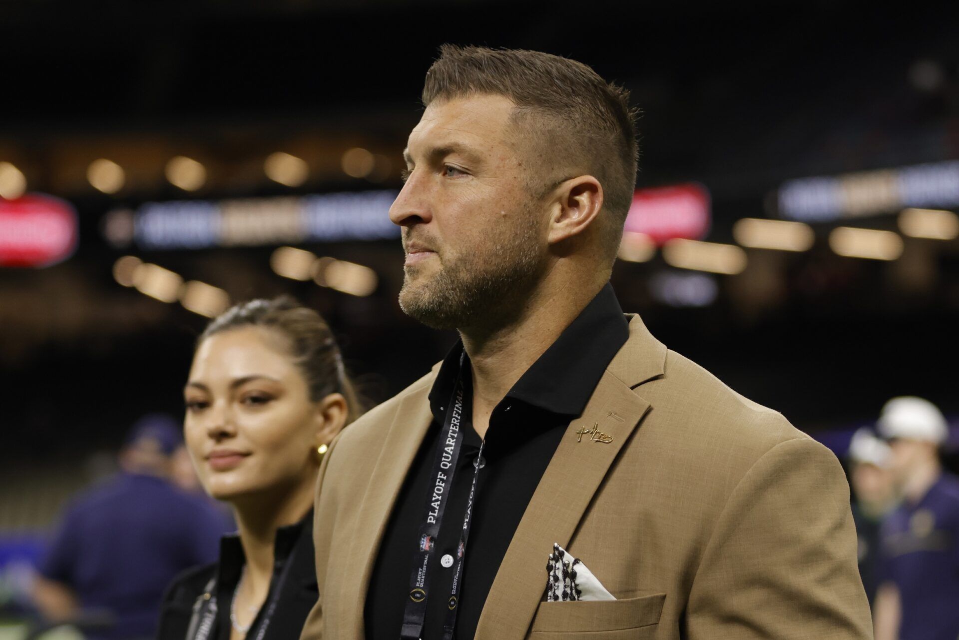 Tim Tebow (left) and wife Demi-Leigh Tebow (right) walk on the field prior to the game between the Notre Dame Fighting Irish and the Georgia Bulldogs at Caesars Superdome.
