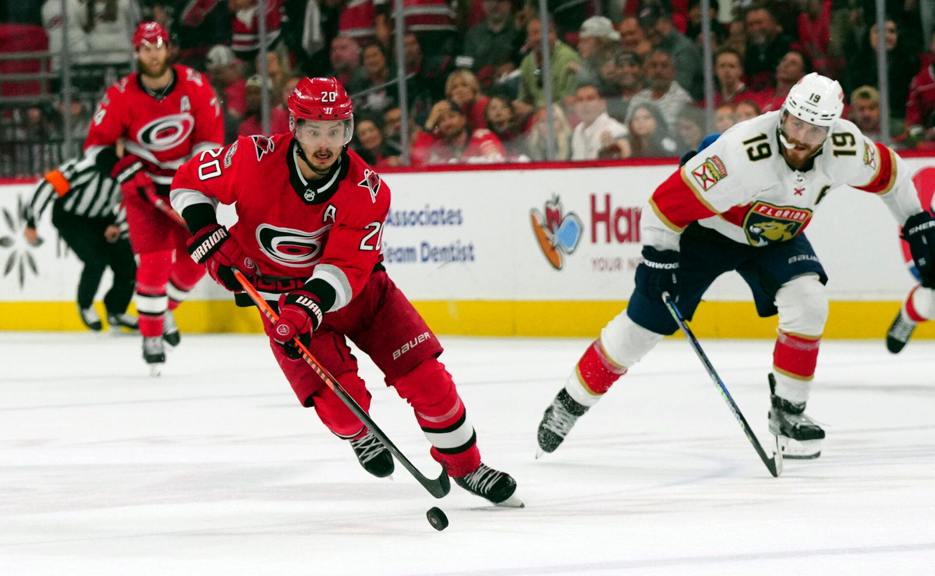 Carolina Hurricanes center Sebastian Aho (20) pushes the puck up the ice against Florida Panthers left wing Matthew Tkachuk (19) in game two of the Eastern Conference Finals of the 2023 Stanley Cup Playoffs at PNC Arena.