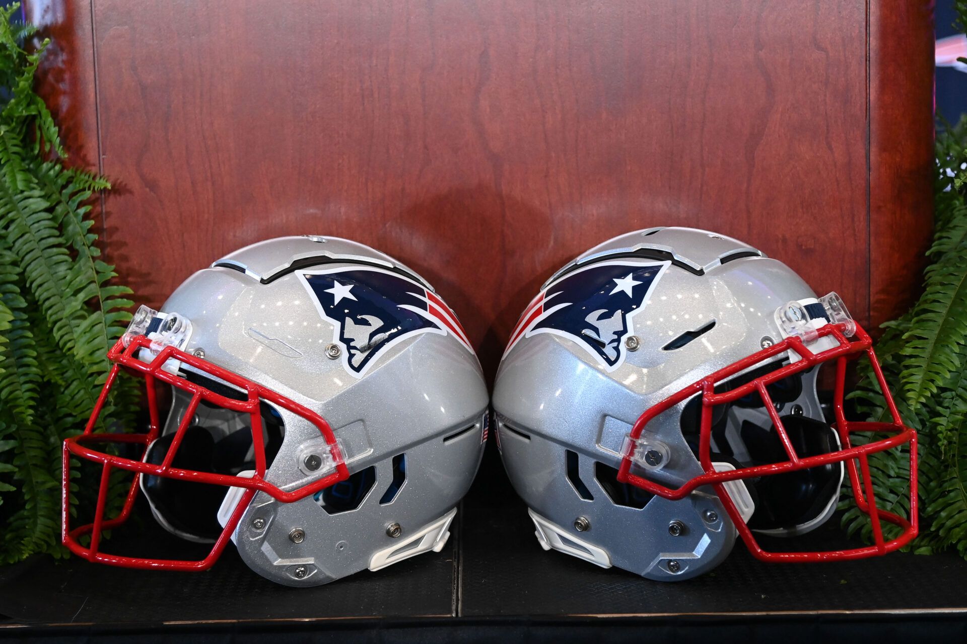 A pair of New England Patriots helmets sit in front of the podium before a press conference at Gillette Stadium.