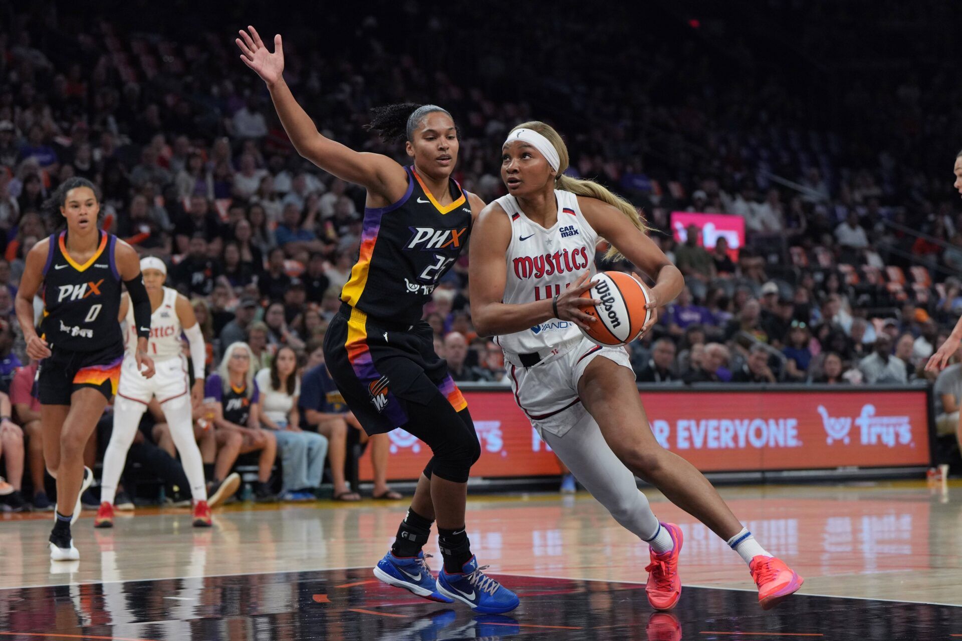 Washington Mystics forward Kiki Iriafen (44) drives on Phoenix Mercury forward Alyssa Thomas (25) in the first half at Footprint Center.