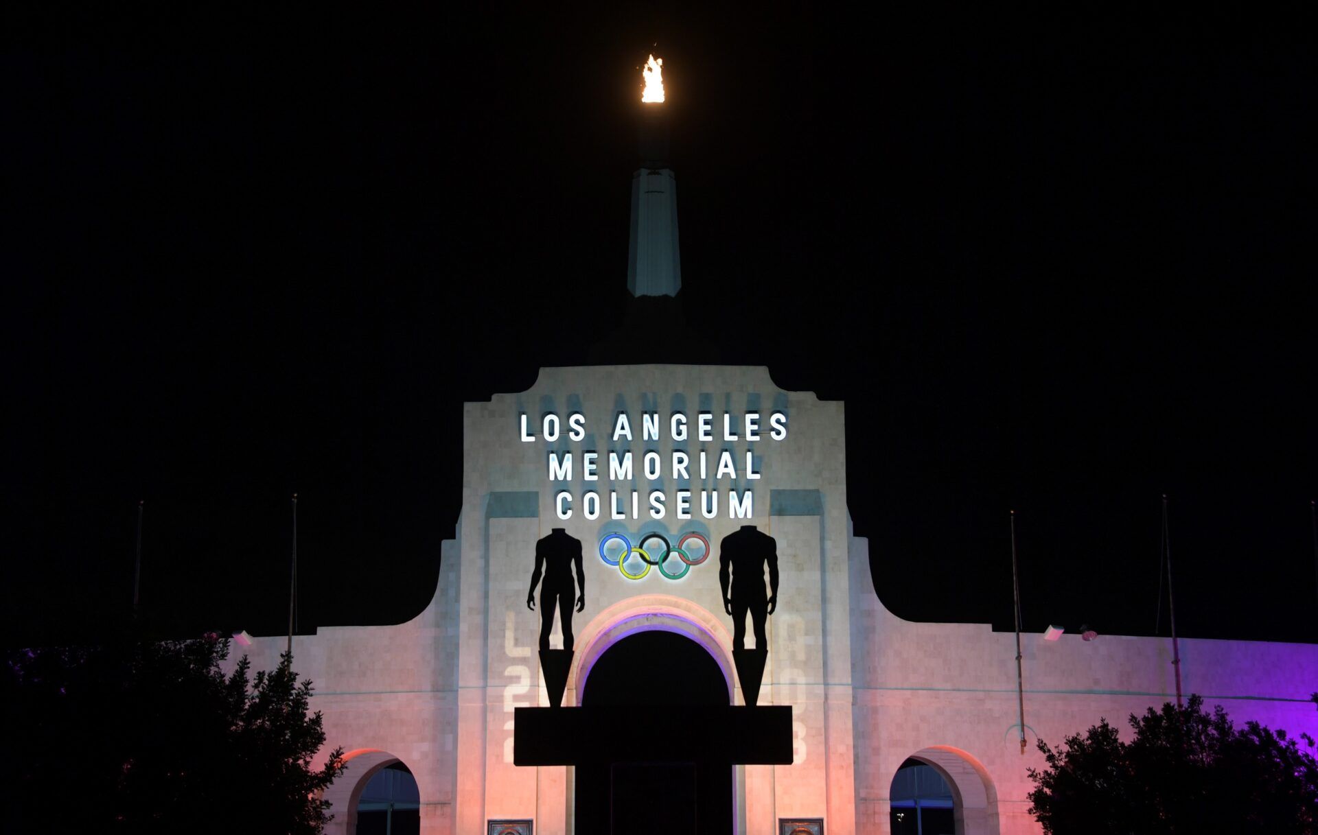 General overall view of the Los Angeles Memorial Coliseum and Olympic torch illuminated in the colors of the LA2028 logo to commemorate the awarding of the 2028 Olympics and Paralympics to Los Angeles.