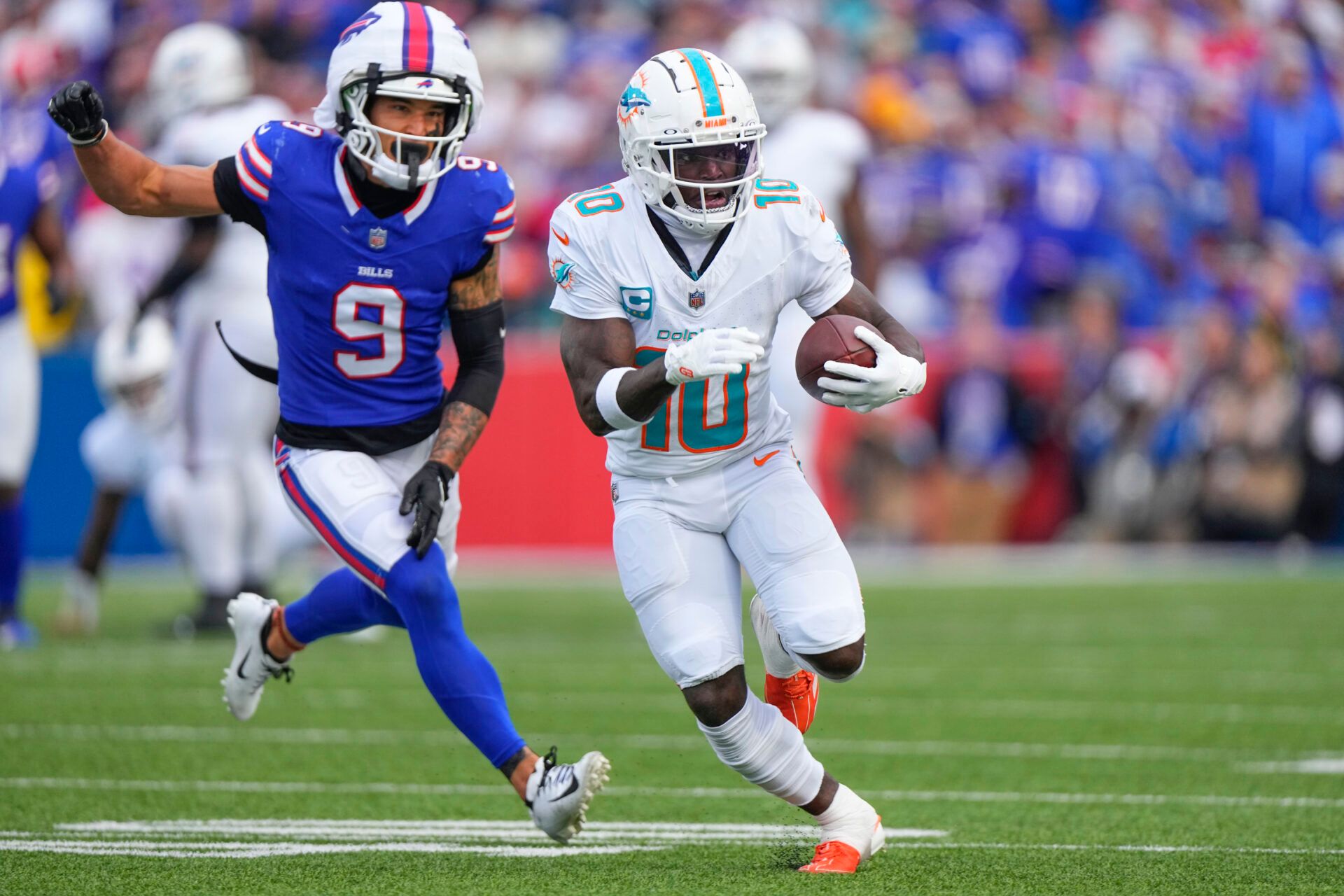 Miami Dolphins wide receiver Tyreek Hill (10) runs with the ball against Buffalo Bills safety Taylor Rapp (9) during the second half at Highmark Stadium.