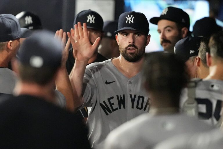 New York Yankees starting pitcher Carlos Rodon (55) is congratulated in the dugout after getting out of the sixth inning against the Tampa Bay Rays at George M. Steinbrenner Field.
