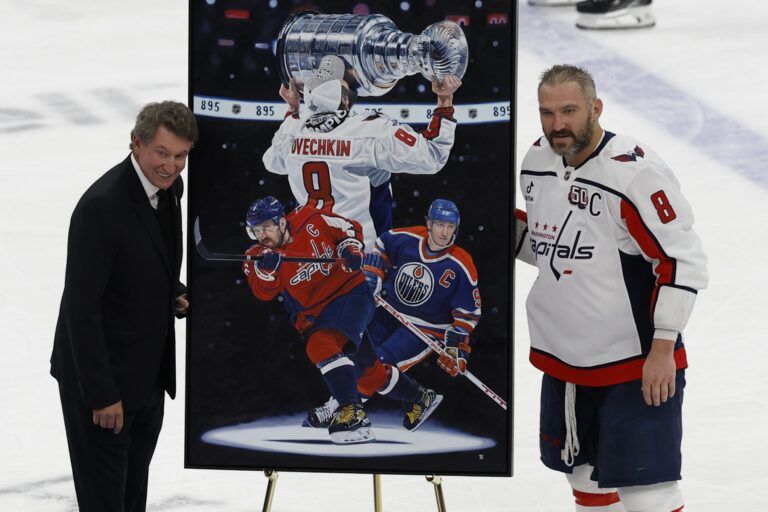 Washington Capitals left wing Alex Ovechkin (8) is honored with a painting by artist Tony Harris by former Canadian-American ice hockey player Wayne Gretzky after scoring in the during the second period against the New York Islanders at UBS Arena. Ovechkin scored the 895th goal of his career, breaking the NHL all-time career goals record previously held by Wayne Gretzky at UBS Arena.