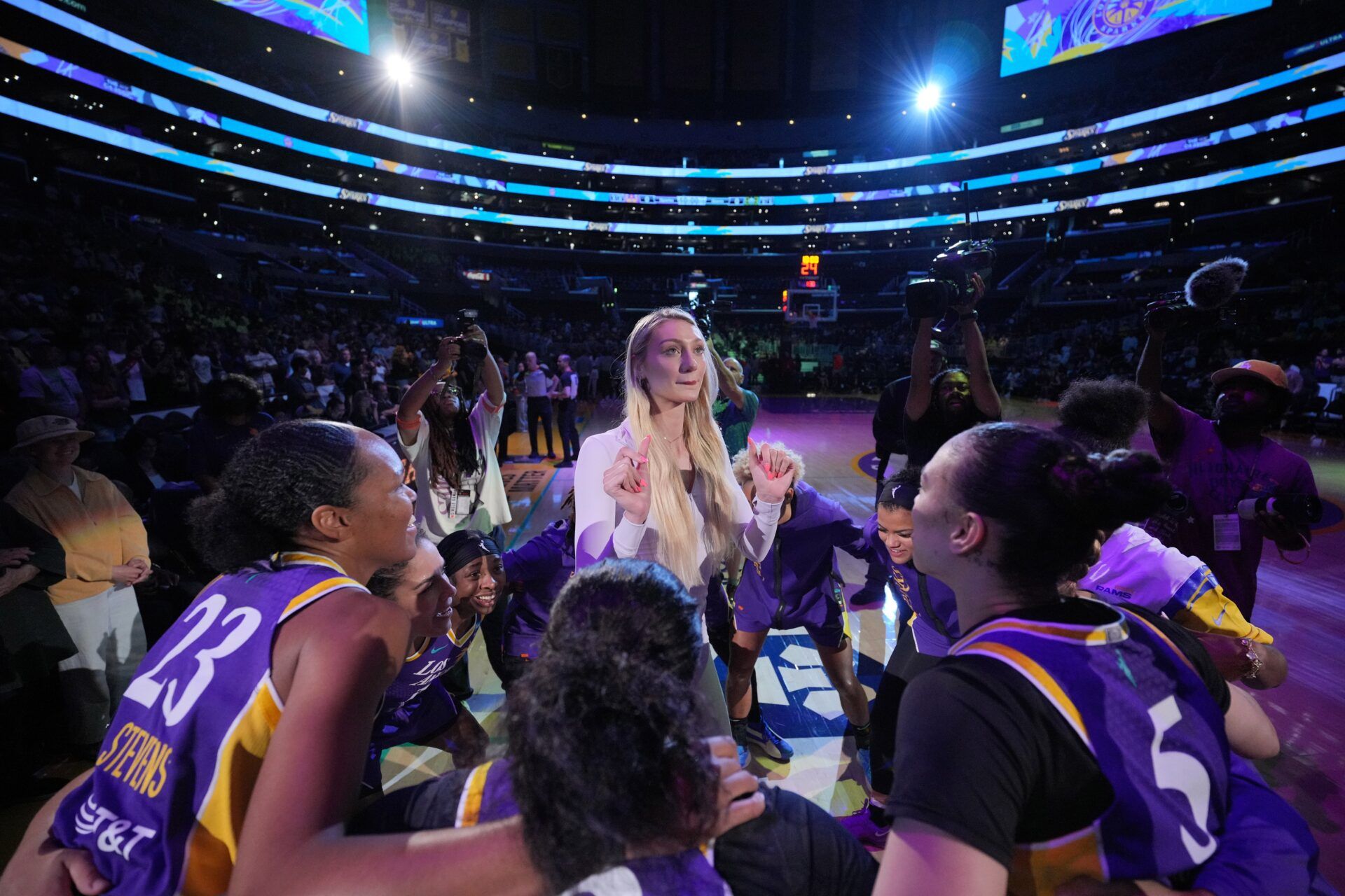 LA Sparks players huddle around forward Cameron Brink during the game against the Seattle Storm at Crypto.com Arena.