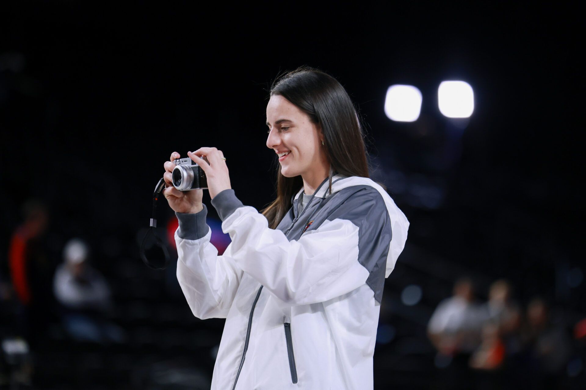 Indiana Fever guard Caitlin Clark (22) takes photos of her teammates warming up before the game against the Washington Mystics at Entertainment & Sports Arena.